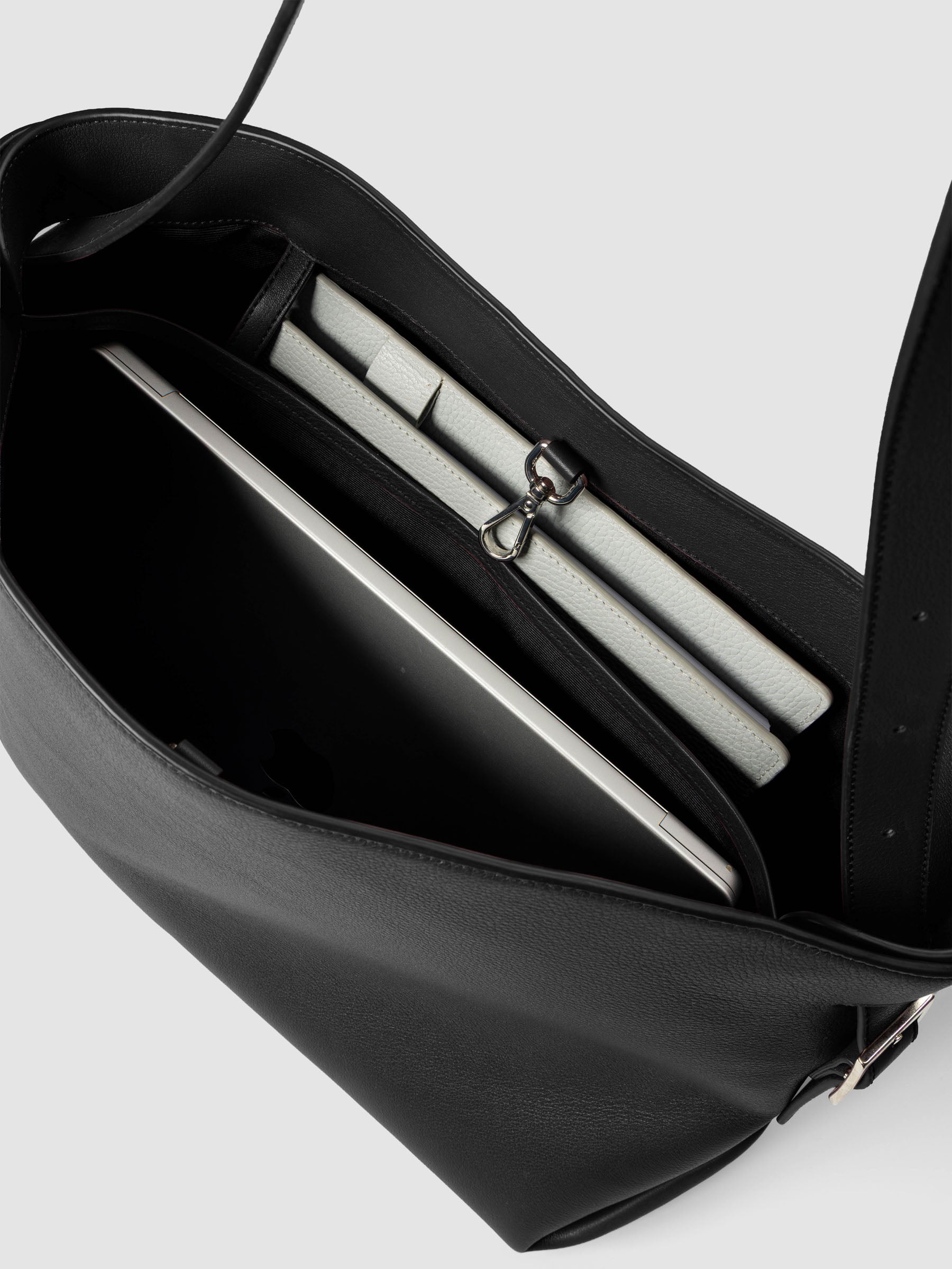 Detail view of a laptop and notebooks inside The Metro Tote in the color Padrillo.