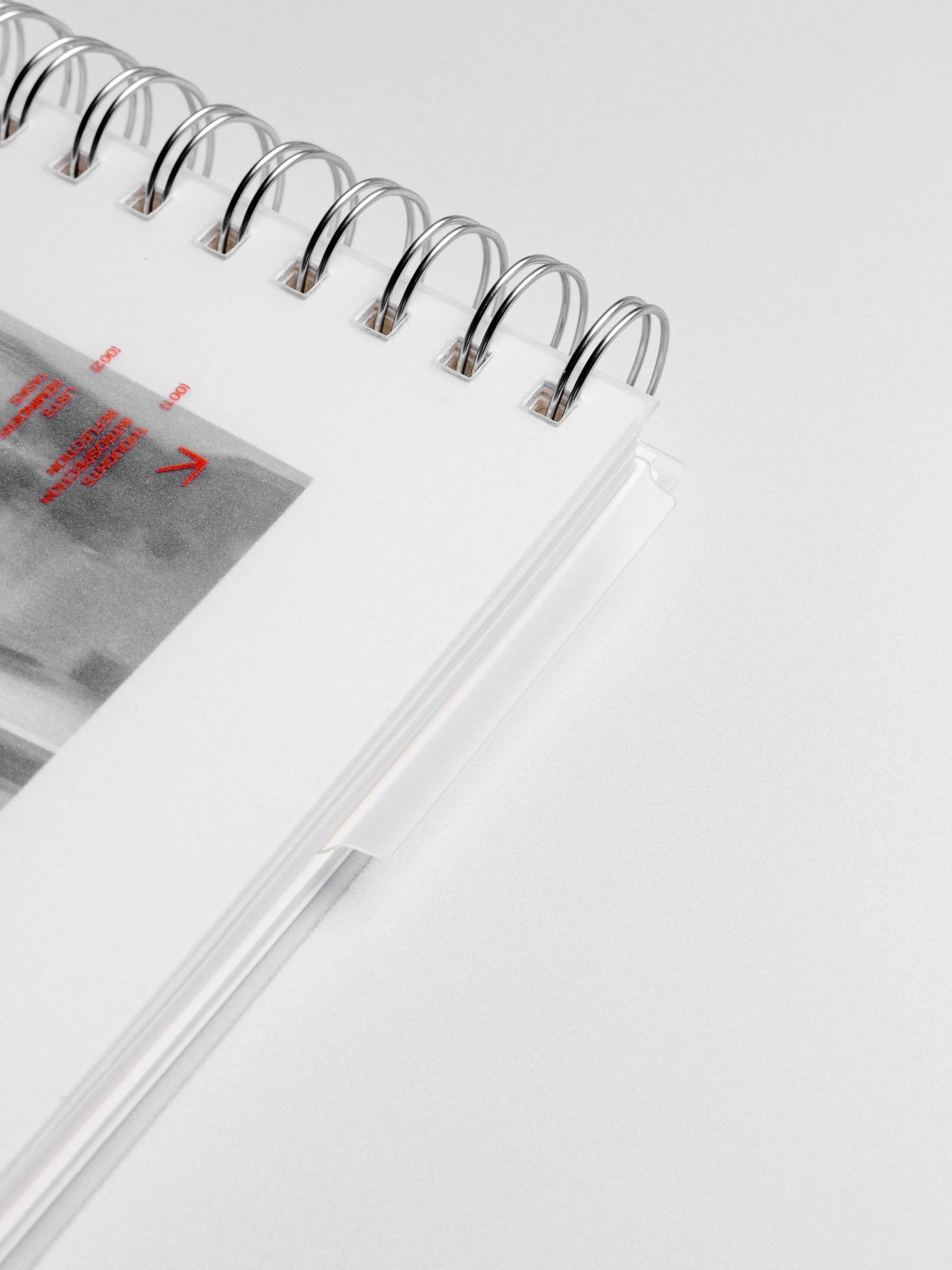 Page marker shown protruding from a closed spiral notebook.