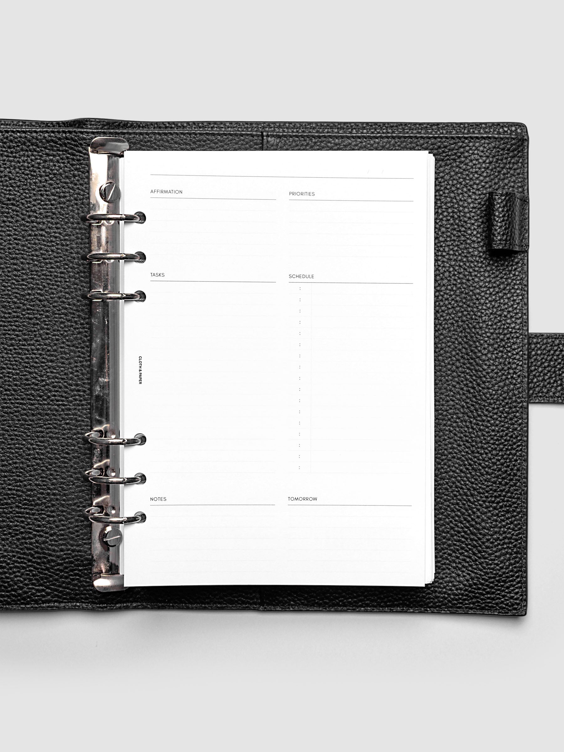 Daily Essentials Planner Inserts shown in size A5 inside a black agenda.