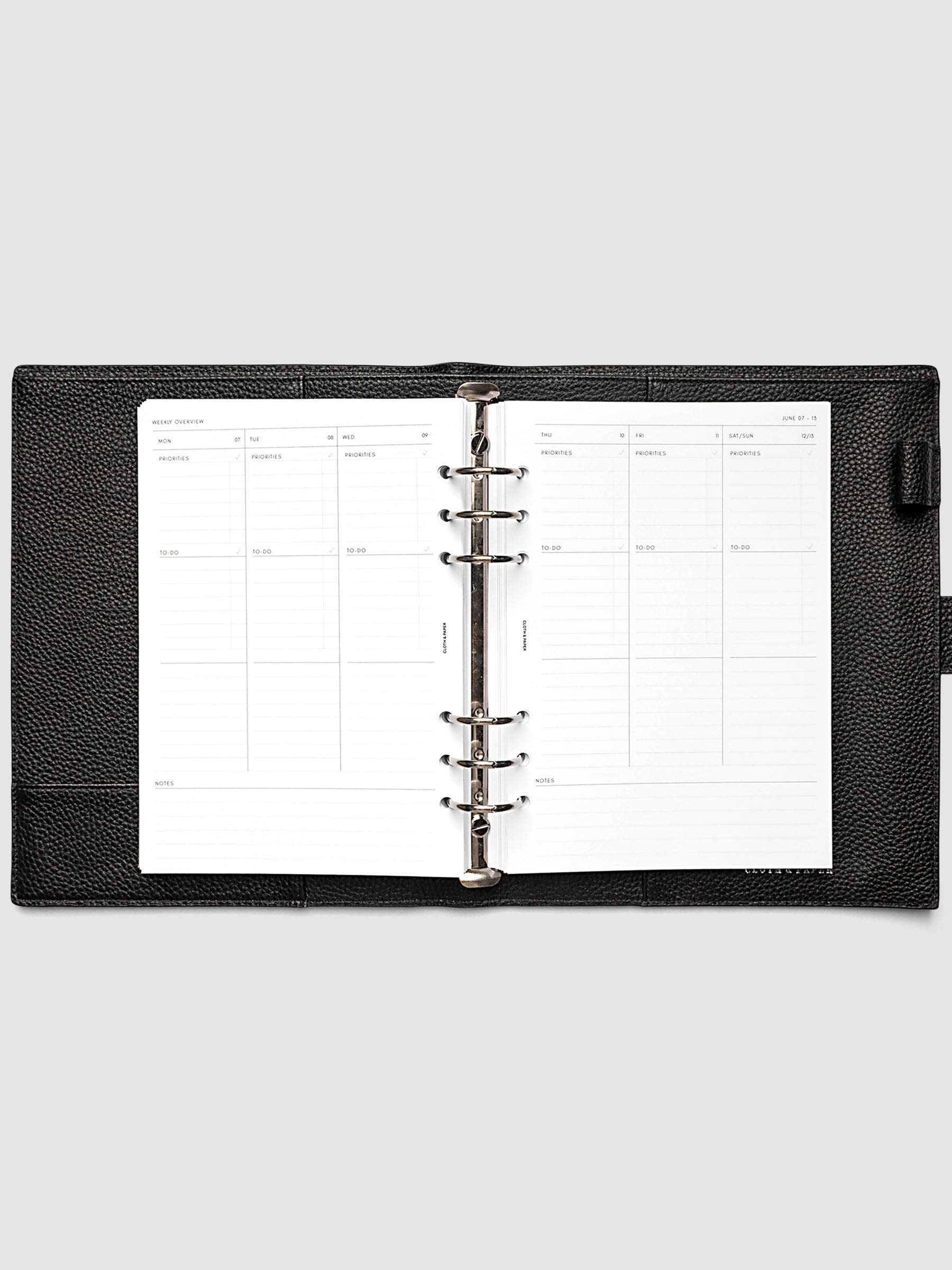 Both pages inside planner: 2027 Dated Weekly Task Planner Inserts, Monday Start, A5 6-Ring Punch, full week-on-two-pages spread showing blank vertical columns for each day with labeled priorities, to-do, and notes sections, Saturday and Sunday combined, and weekly notes section along the bottom, shown inside a planner