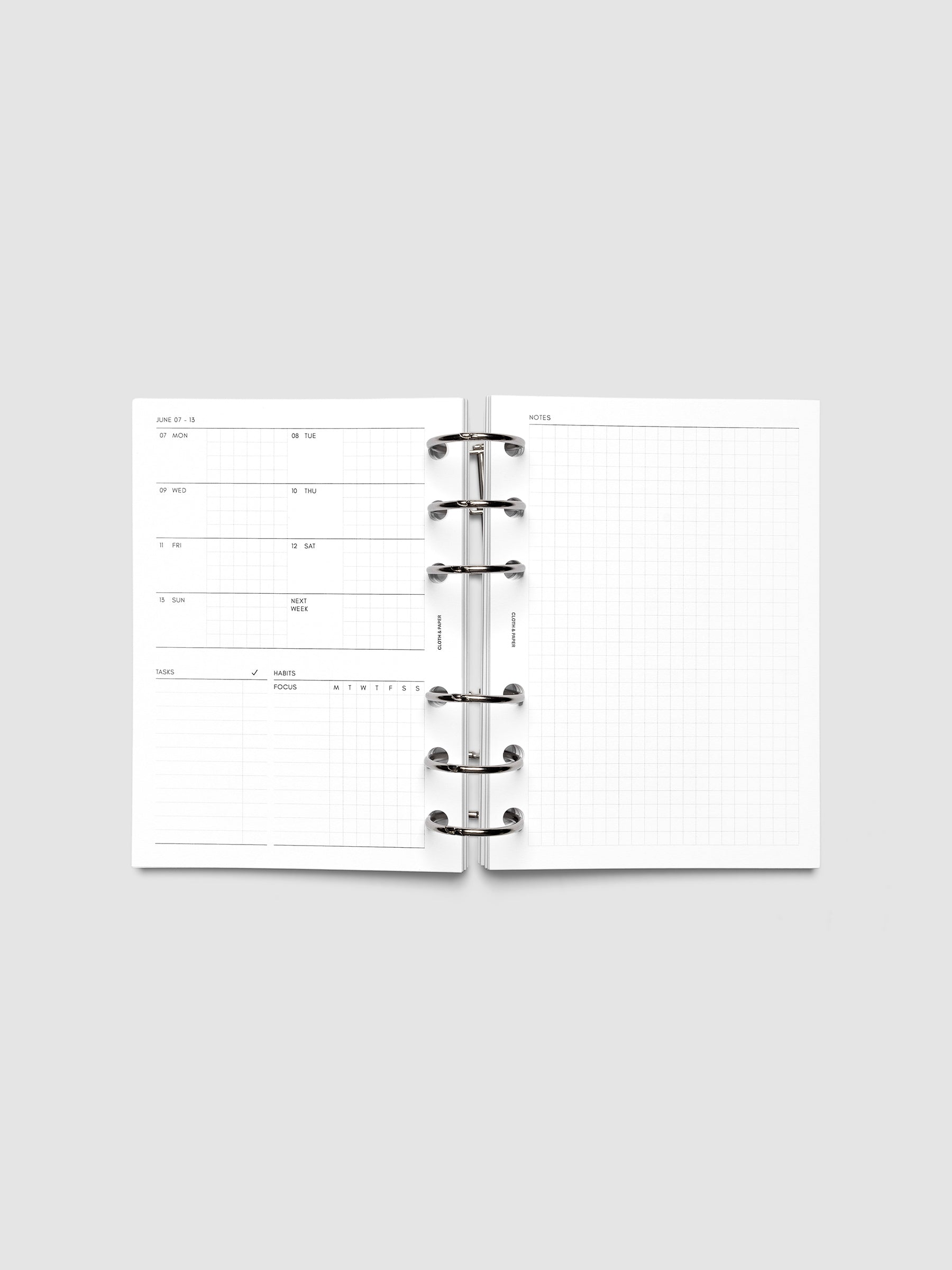 Open planner showing the full two-page 2027 Dated Weekly Admin spread in A6 6-Ring Punch size, with the weekly overview and task and habit tracking sections on the left and a graph notes layout on the right