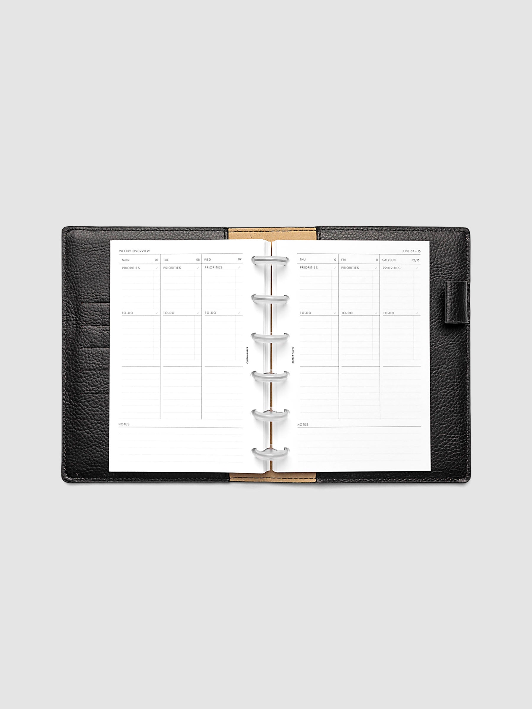 Both pages inside planner: 2027 Dated Weekly Task Planner Inserts, Monday Start, CP Petite 6-Disc Punch, full week-on-two-pages spread showing blank vertical columns for each day with labeled priorities, to-do, and notes sections, Saturday and Sunday combined, and weekly notes section along the bottom, shown inside a planner