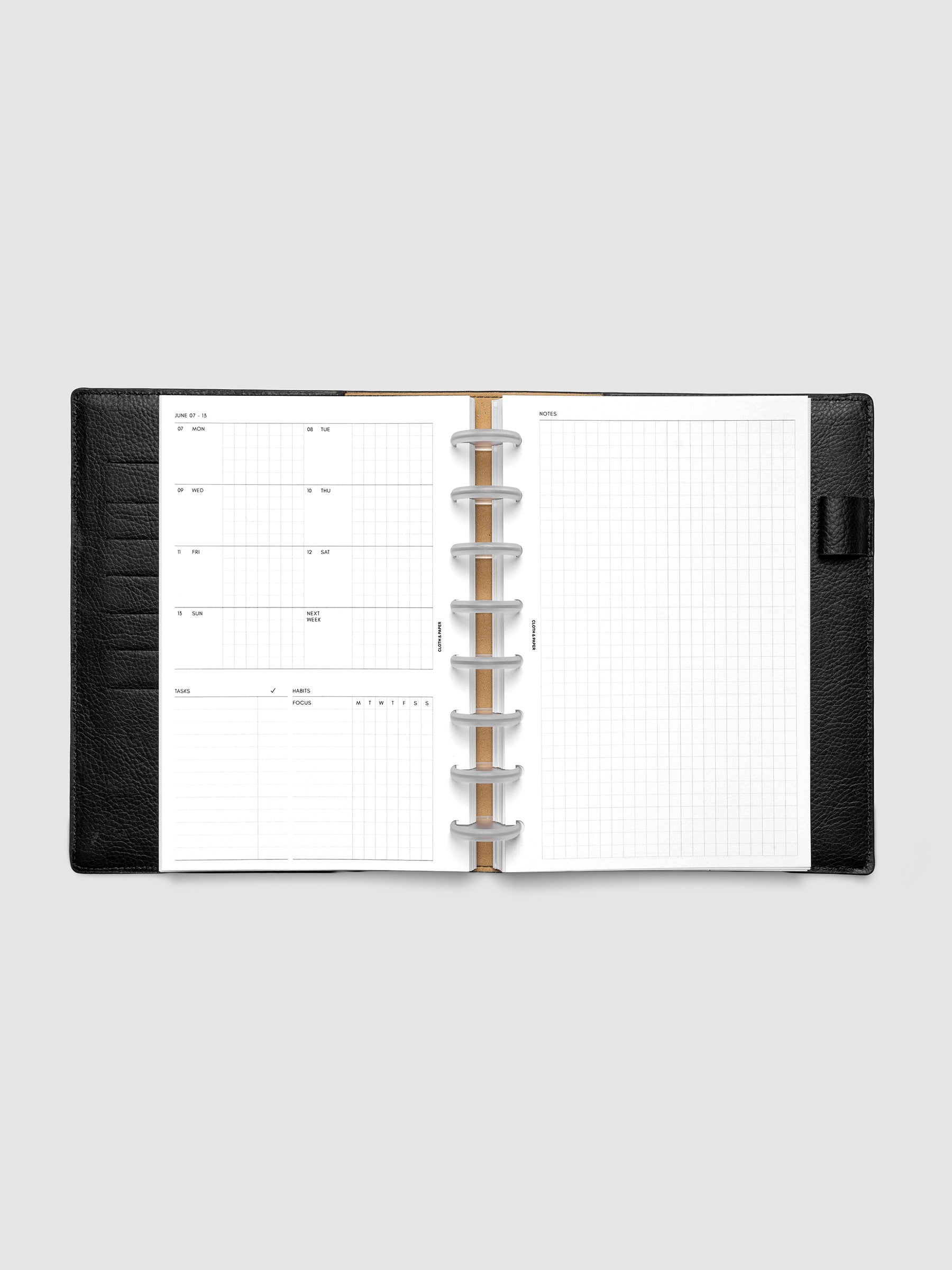 Open planner showing the full two-page 2027 Dated Weekly Admin spread in Half Letter 8-Disc Punch size, with the weekly overview and task and habit tracking sections on the left and a graph notes layout on the right