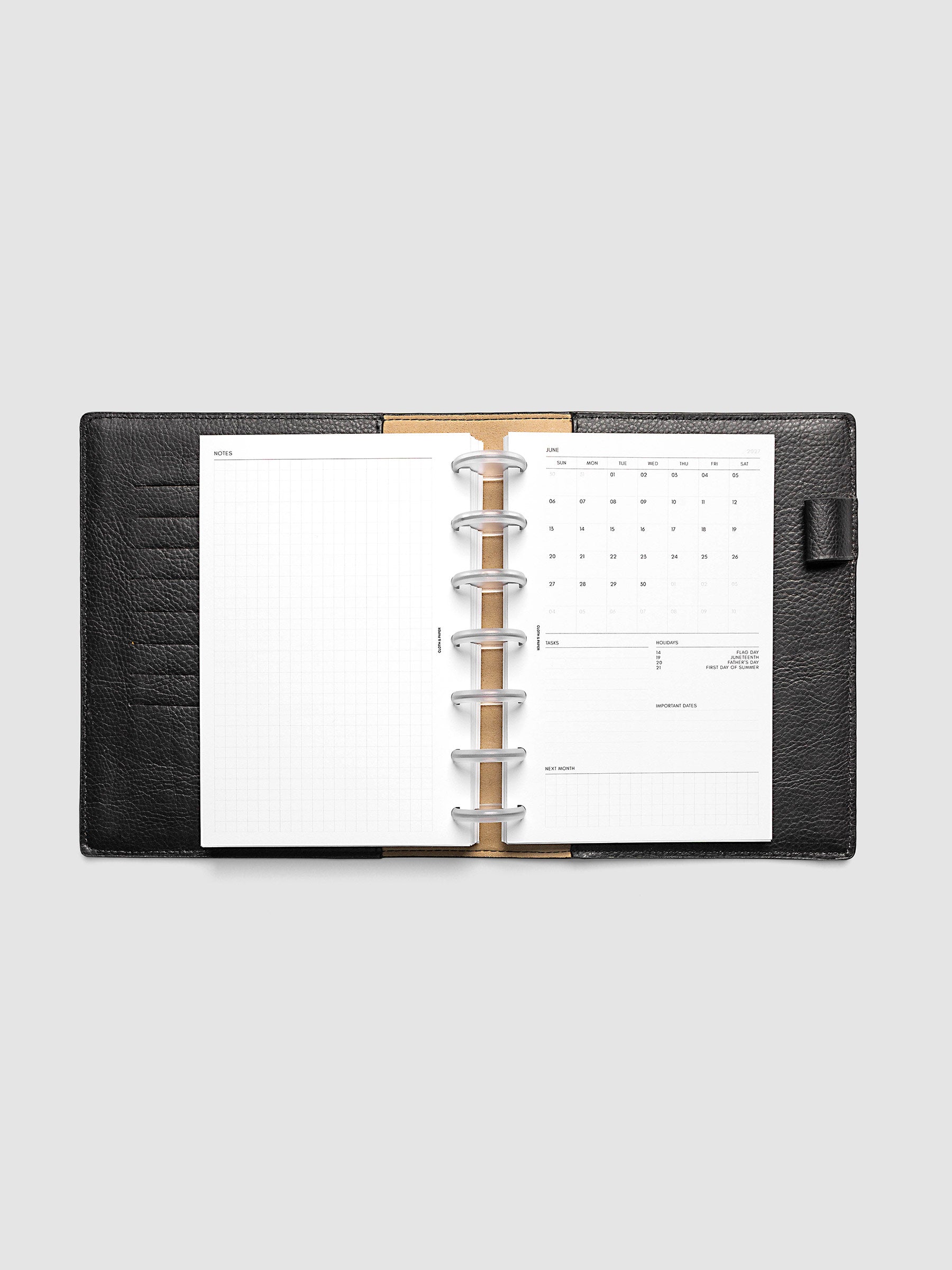2027 Dated Monthly Admin Inserts open inside a HP Mini 7-Disc Punch discbound planner, showing the fully open graph left page alongside the Sunday start monthly calendar, task section, holiday reference, important dates, and next month preview on the right.