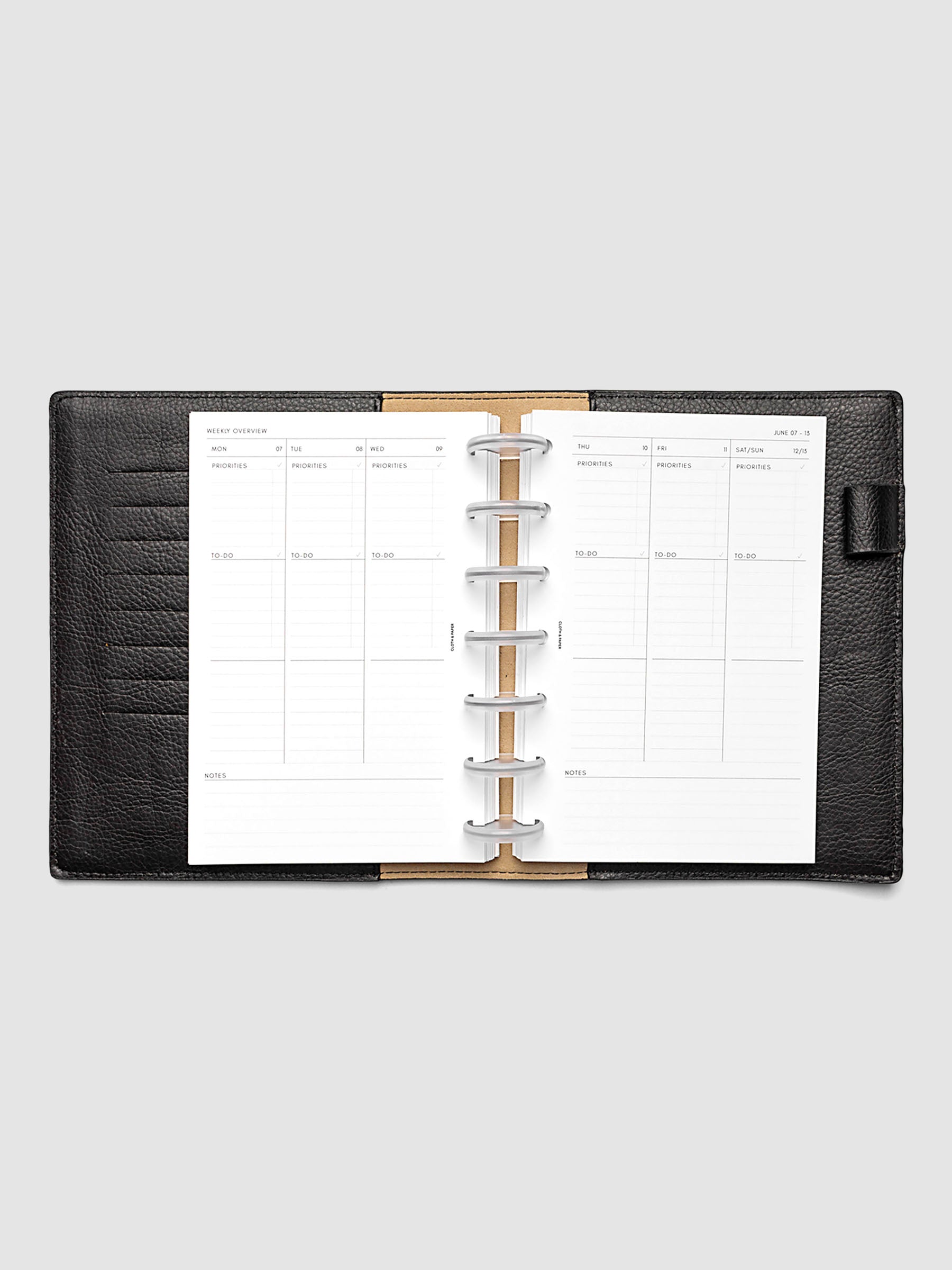 Both pages inside planner: 2027 Dated Weekly Task Planner Inserts, Monday Start, HP Mini 7-Disc Punch, full week-on-two-pages spread showing blank vertical columns for each day with labeled priorities, to-do, and notes sections, Saturday and Sunday combined, and weekly notes section along the bottom, shown inside a planner