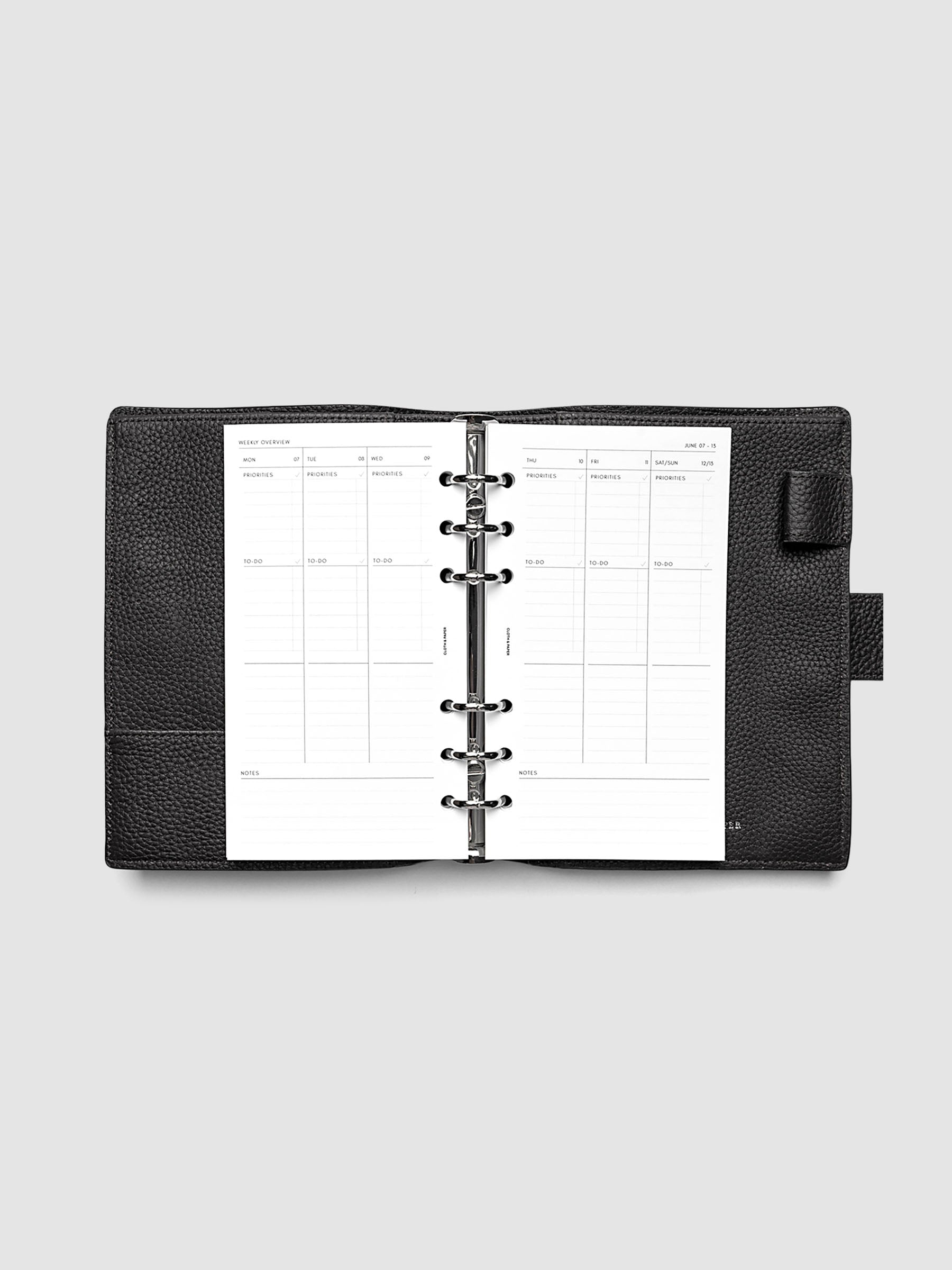 Both pages inside planner: 2027 Dated Weekly Task Planner Inserts, Monday Start, Personal 6-Ring Punch, full week-on-two-pages spread showing blank vertical columns for each day with labeled priorities, to-do, and notes sections, Saturday and Sunday combined, and weekly notes section along the bottom, shown inside a planner