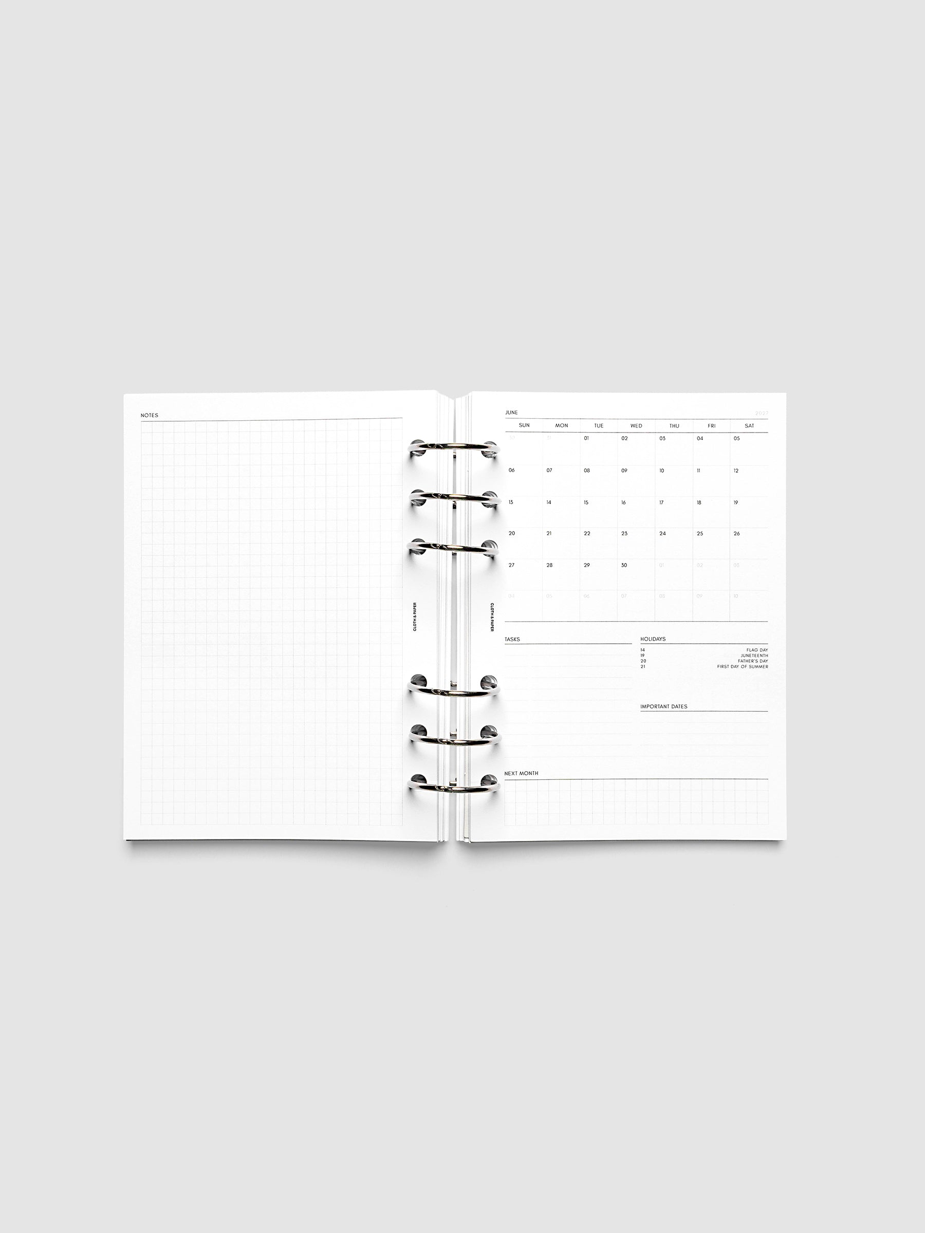 2027 Dated Monthly Admin Inserts open inside a Personal Wide 6-Ring Punch 6-ring planner, showing the fully open graph left page alongside the Sunday start monthly calendar, task section, holiday reference, important dates, and next month preview on the right.