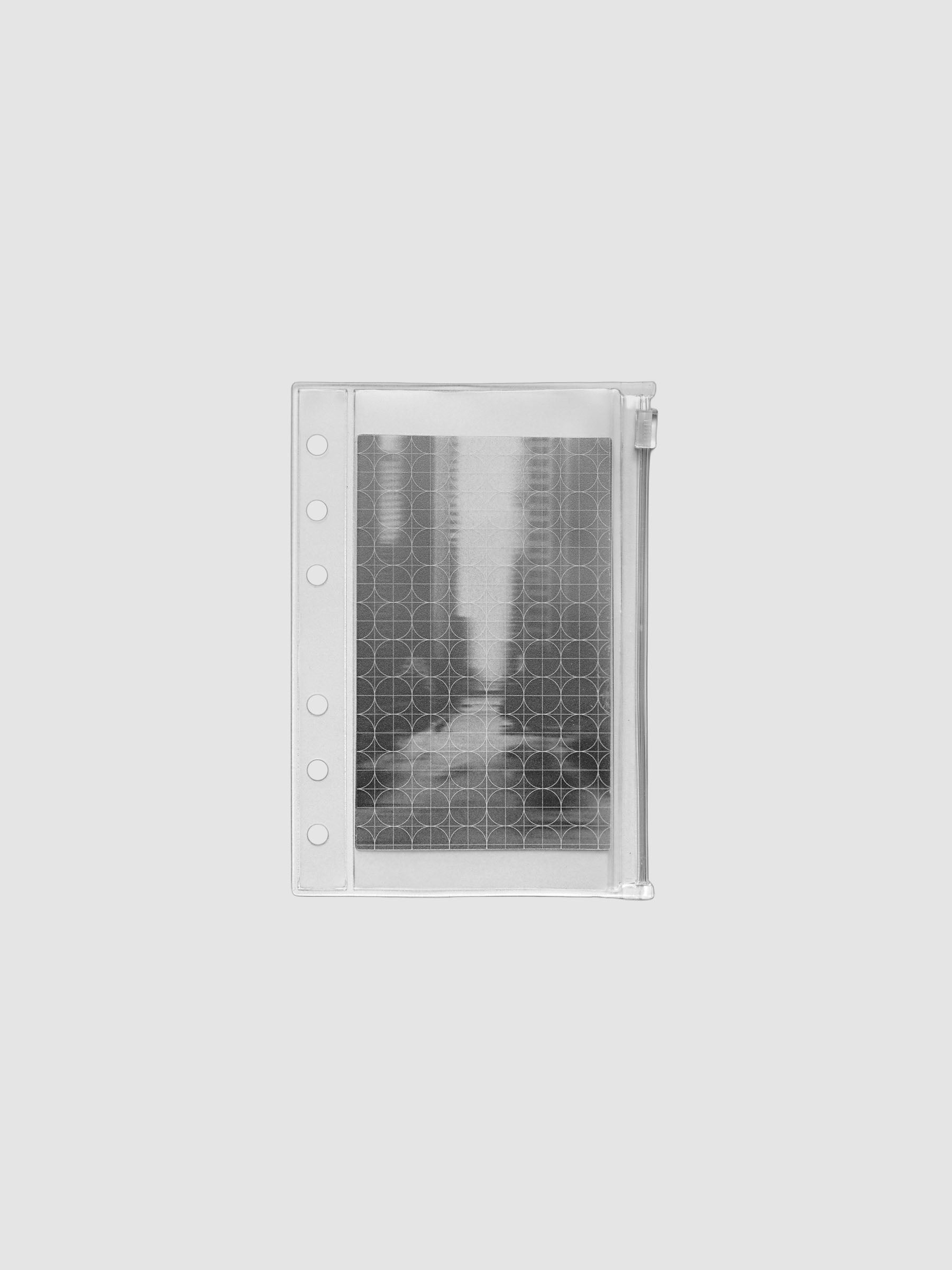 Zippered transparent pouch pre-punched for A6 size ring bound planners and notebooks. Features a graph and a photographic decorative inner insert.