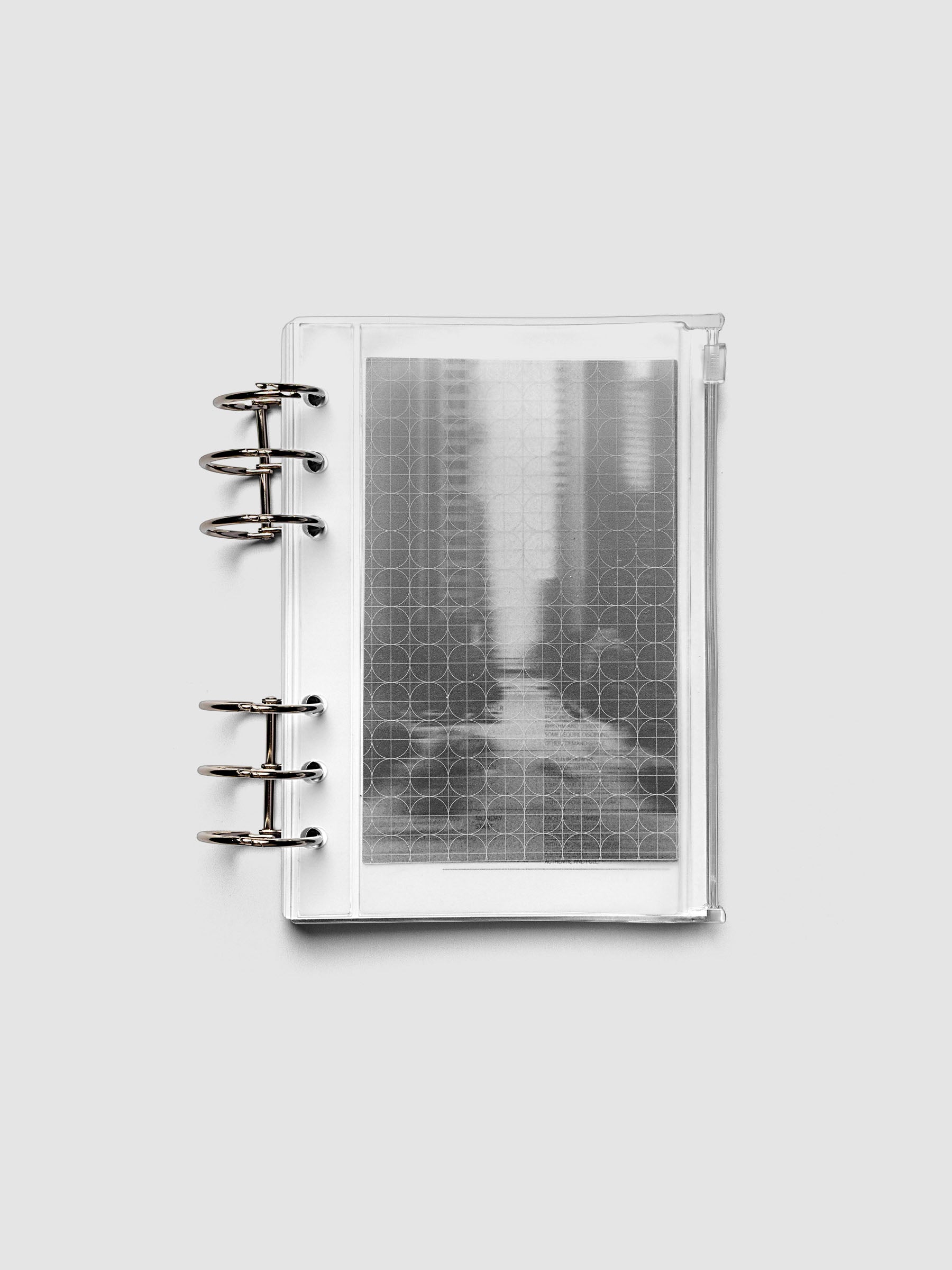 Side zipper transparent storage pouch for planners with decorative inner graph and photograph layers shown ring bound in size Personal Wide.