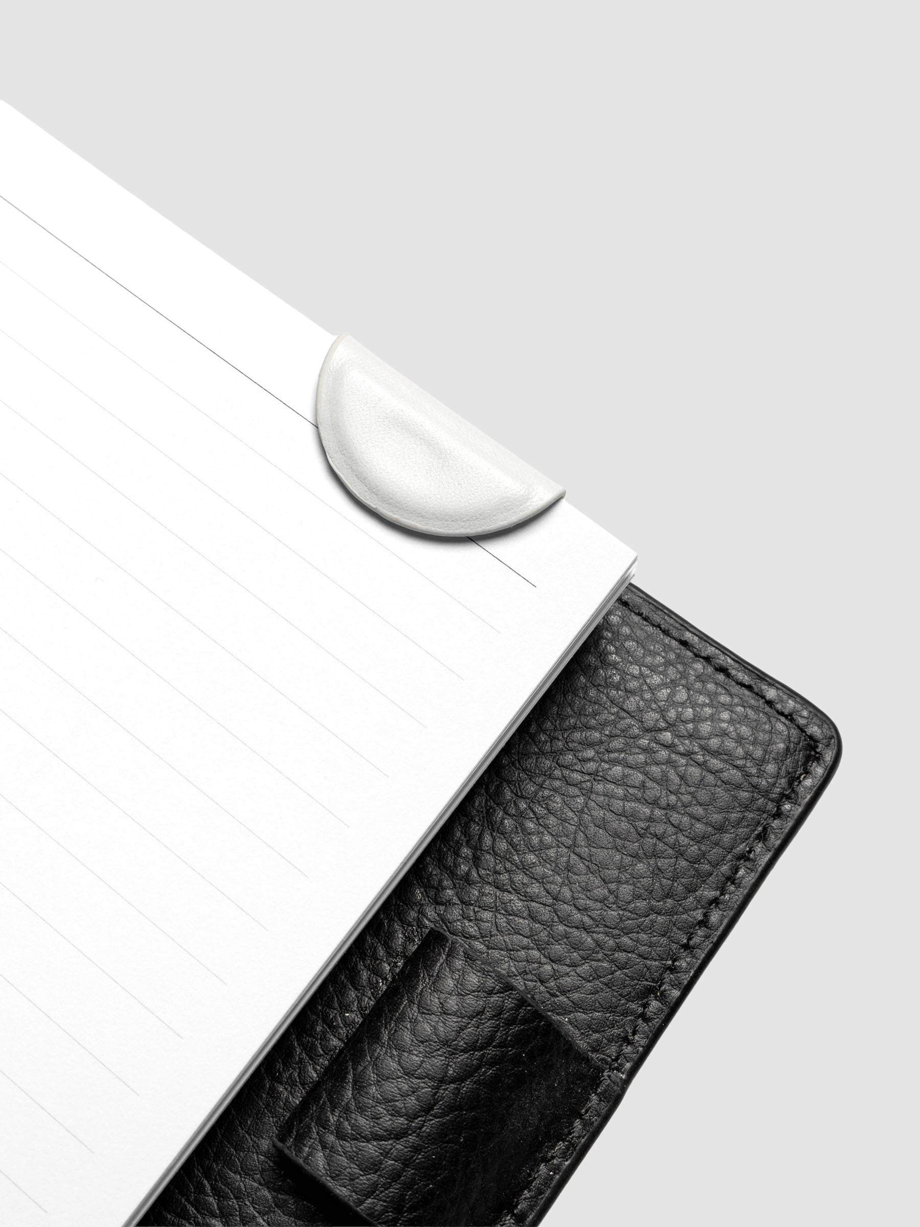 Aspen (white) mini magnetic bookmark folded in half over planner pages