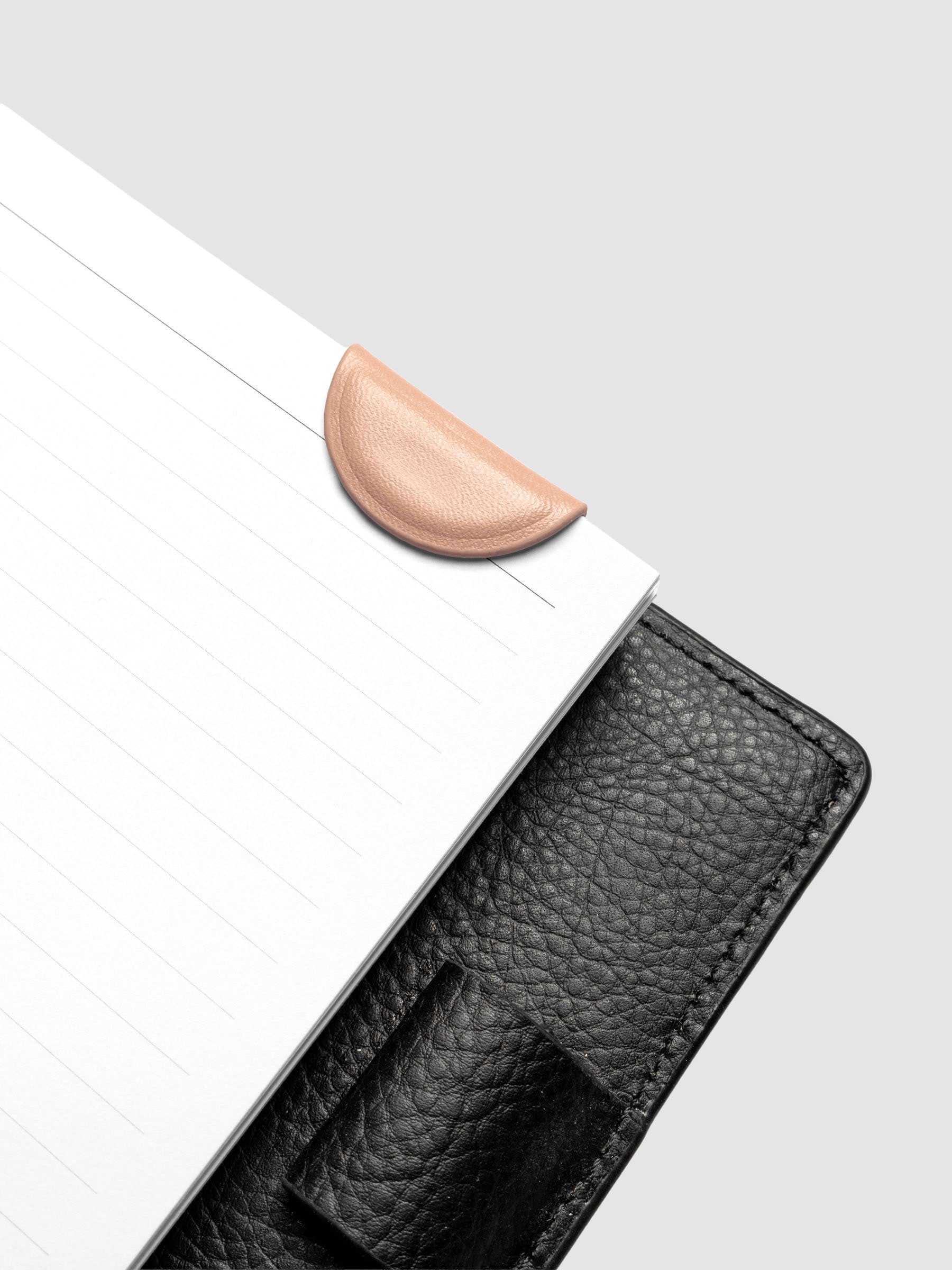 Dirty Chai (salmon) mini magnetic bookmark folded in half over a bookmark