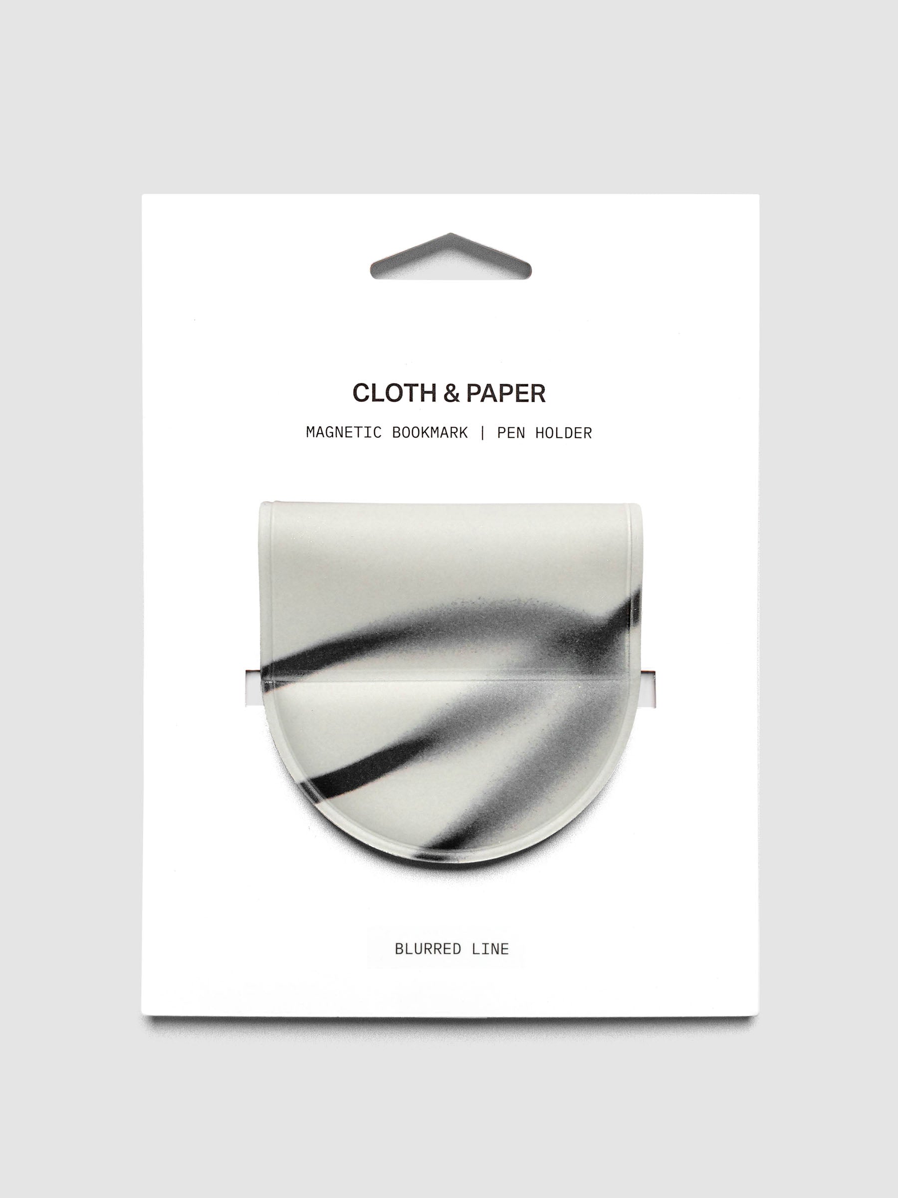 Magnetic Bookmark | Pen Holder | Vinyl in Blurred Line shown in retail packaging with a white base and sweeping dark gray brushstroke pattern