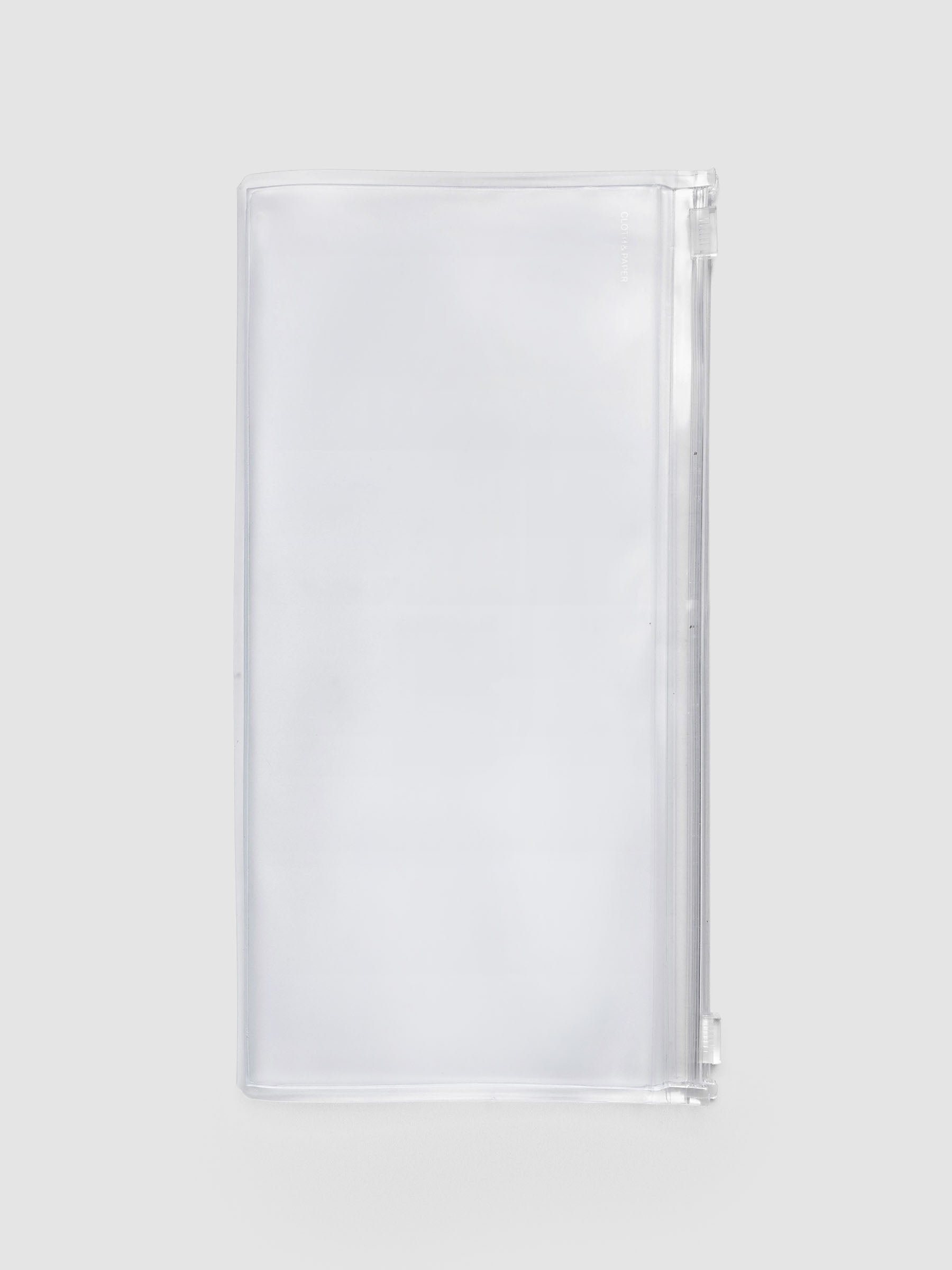 Storage Holder Travel Notebook A5 Slim, empty and closed, frosted clear plastic with silver foil logo, front view
