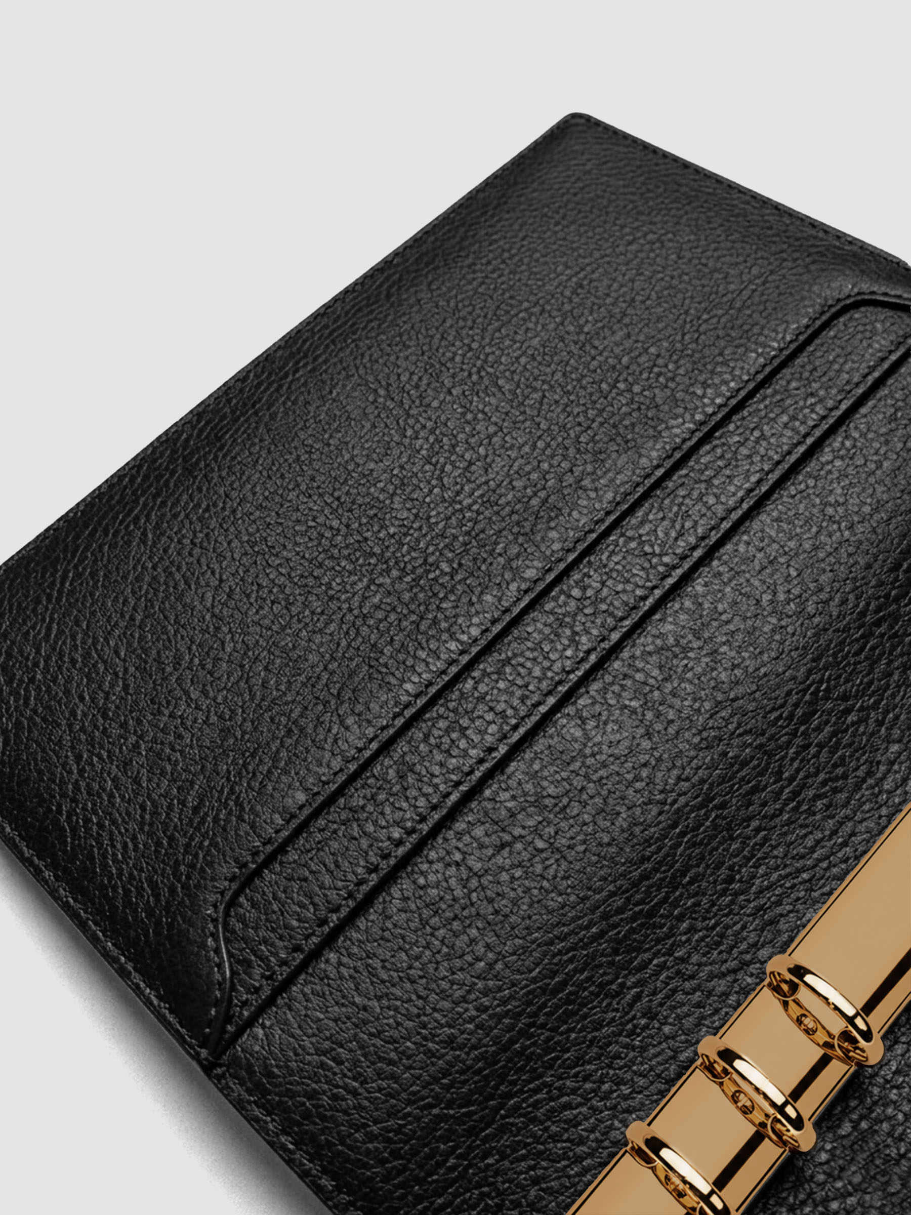 Detail of large interior pockets on the left side of a black genuine leather A5 planner cover