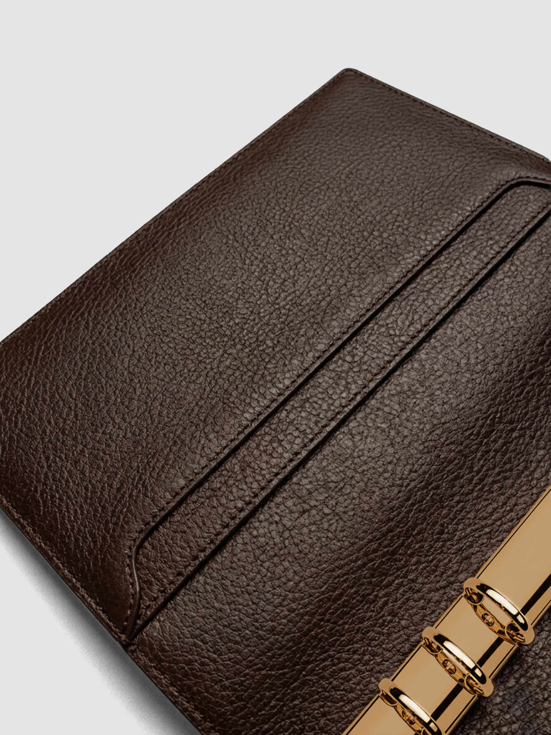Detail of large interior pockets on the left side of a dark brown genuine leather A5 planner cover