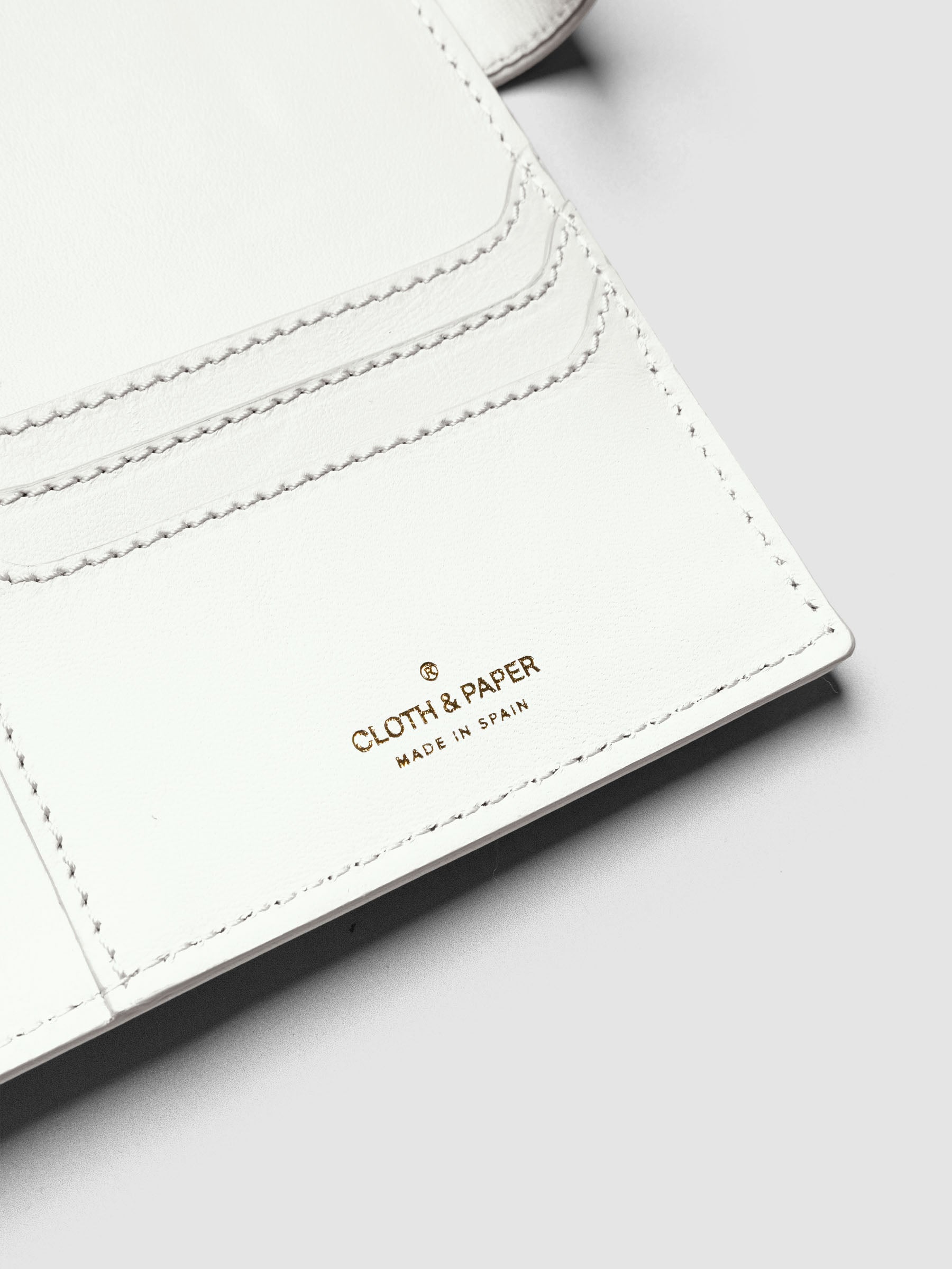 Detail of three credit card slots on the right interior of an off-white genuine leather A5 planner cover