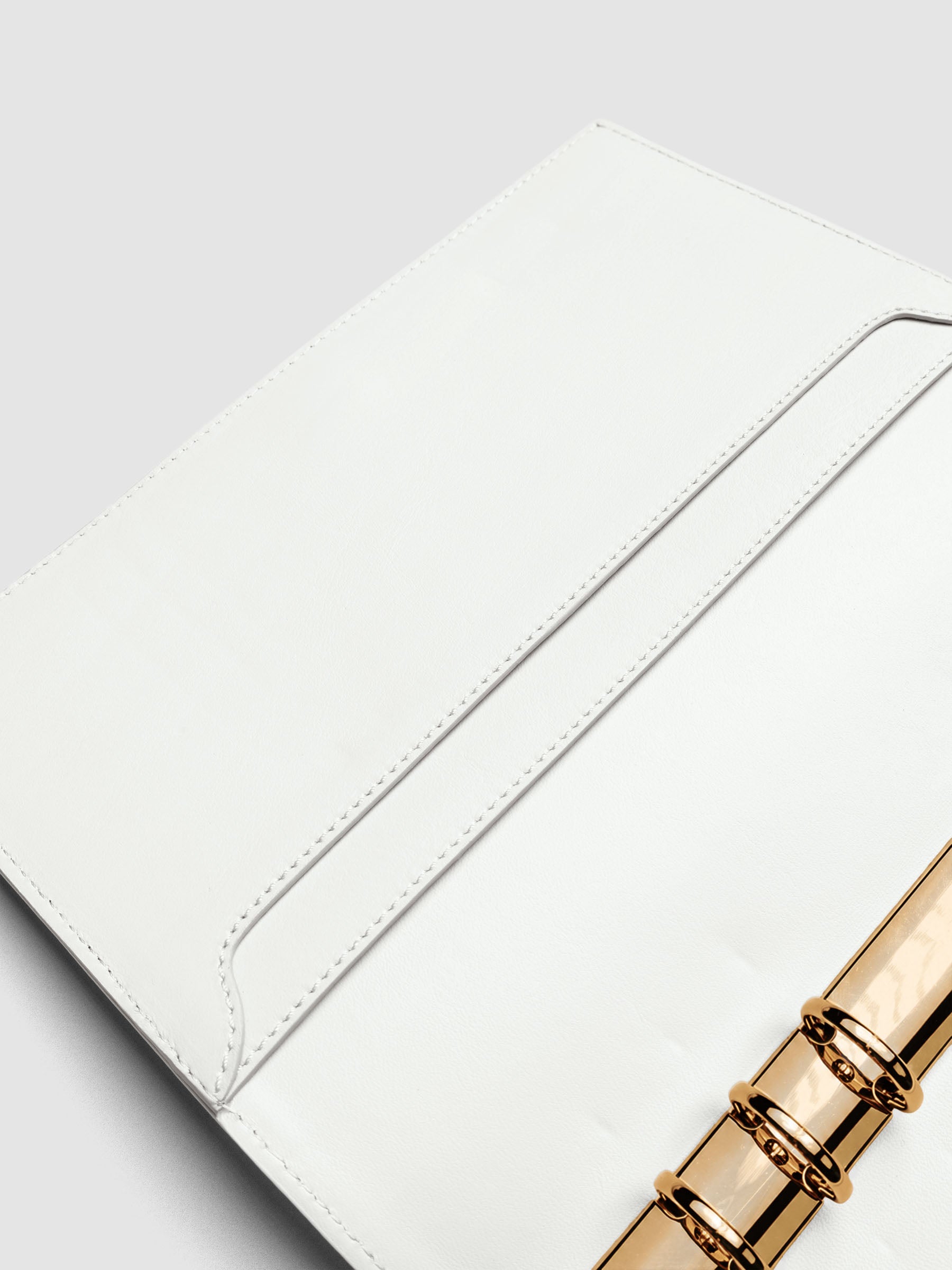 Detail of large interior pockets on the left side of an off-white genuine leather A5 planner cover