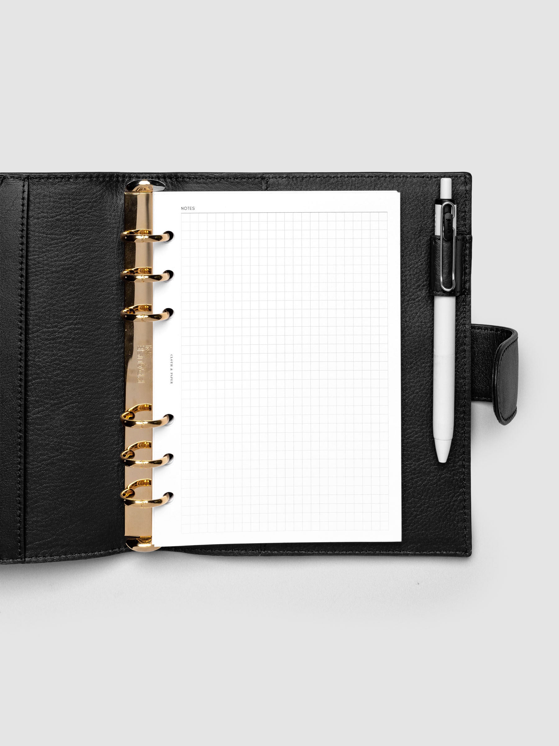 Open black genuine leather Personal Wide 6-ring planner cover with inserts inside, gold Krause rings visible