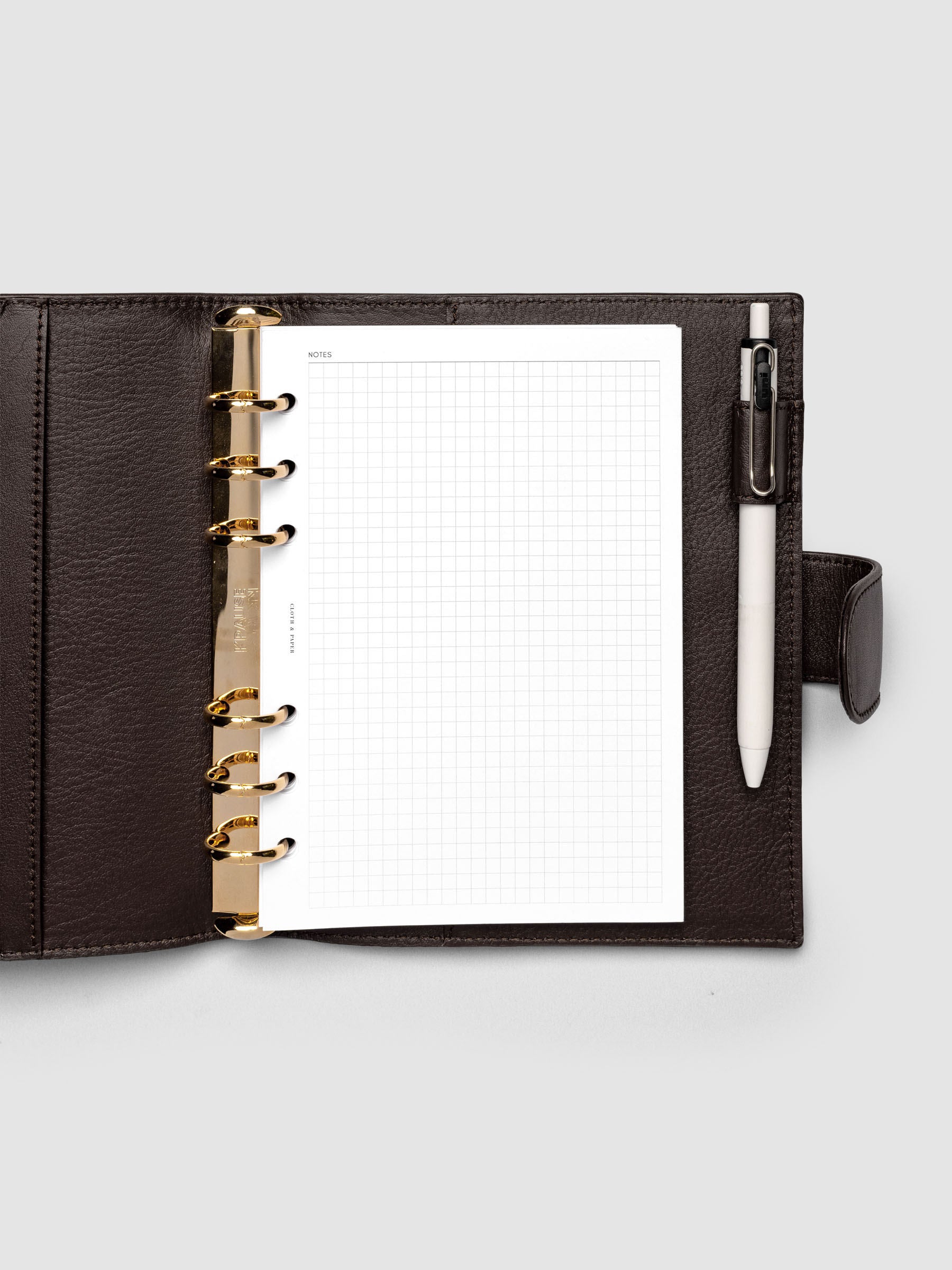 Open dark brown genuine leather Personal Wide 6-ring planner cover with inserts inside, gold Krause rings visible