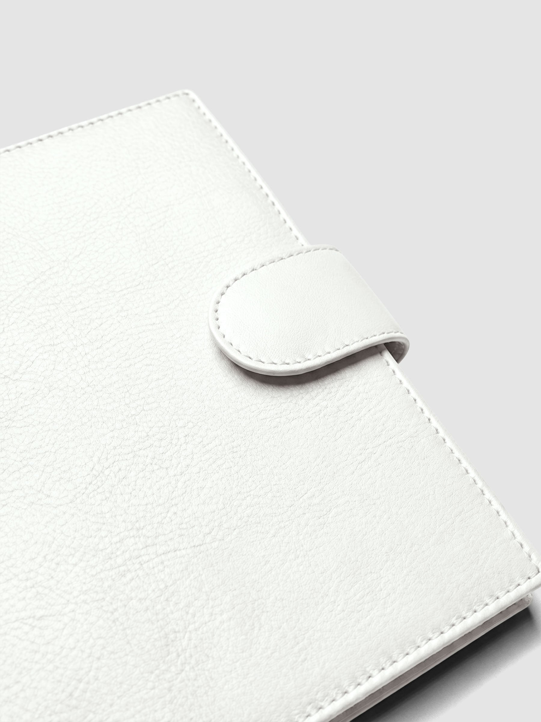 Detail of gold magnetic snap closure securing an off-white genuine leather Personal Wide 6-ring planner cover shut