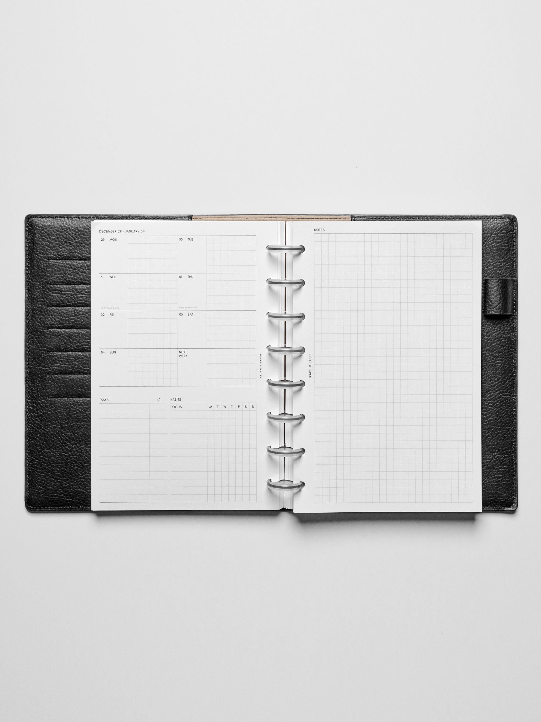 Image shows the Monday Start 2026 Dated Weekly Admin Planner Insert in a black leather disc-bound planner.