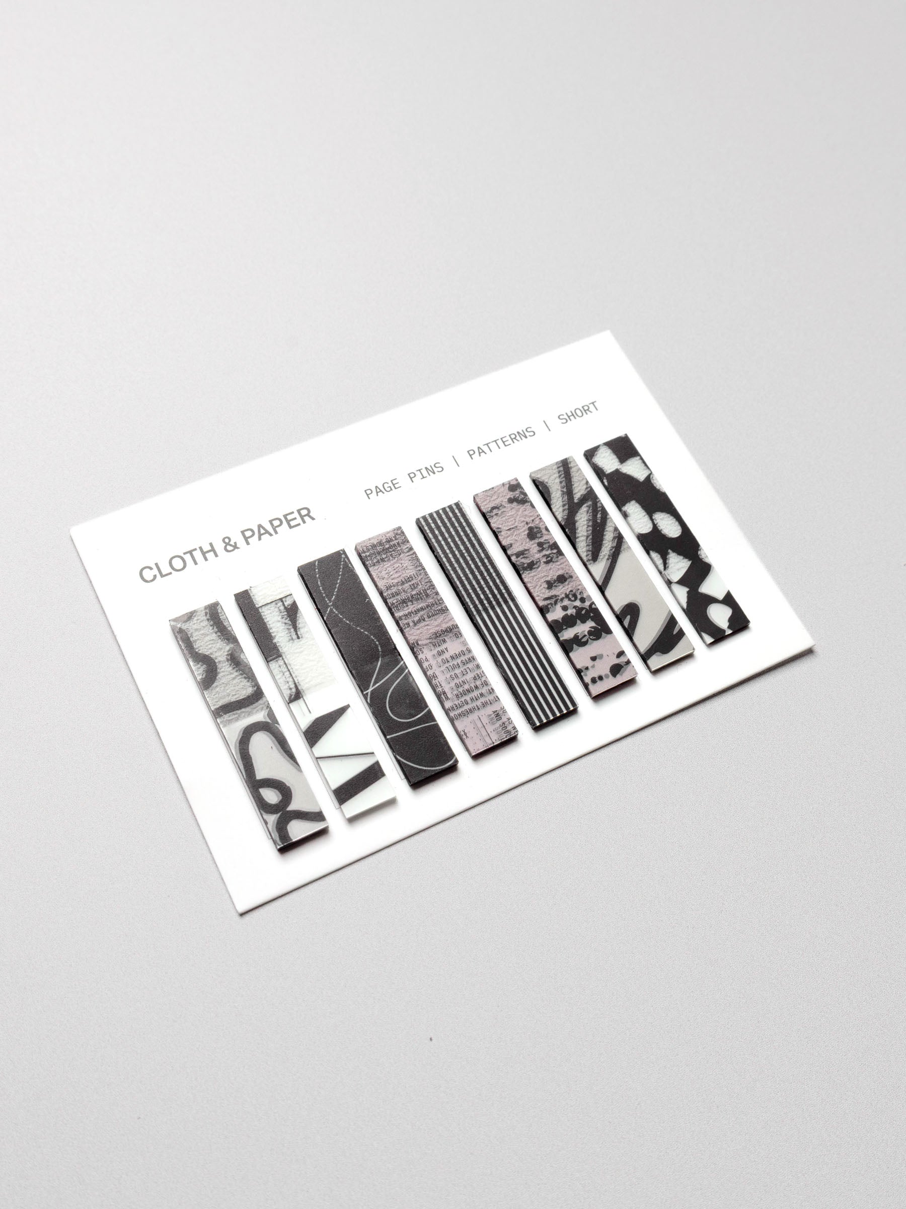 Short page pins displayed in their packaging on a neutral background.