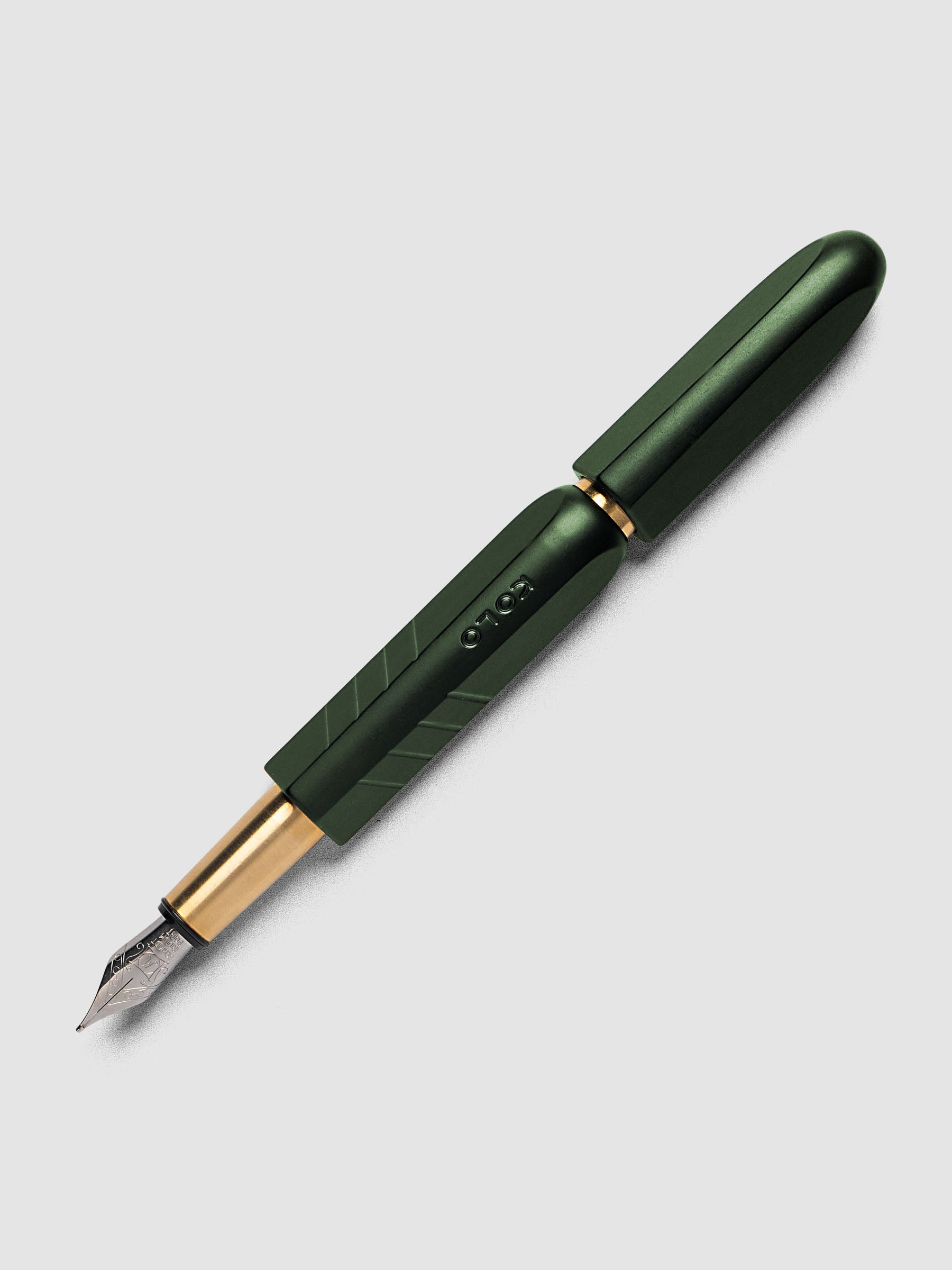 Kolo Tino Fountain Pen in Anodized Aluminum Verdant, a deep forest green barrel with gold accents and silver medium nib shown capped, full pen angled view