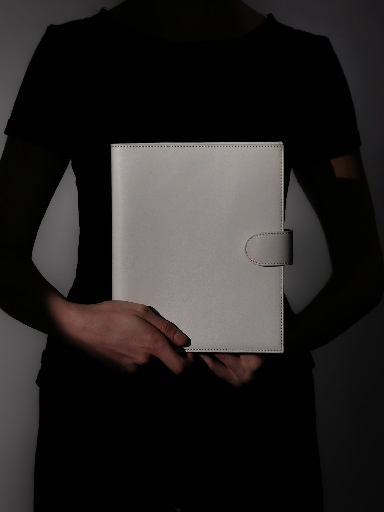 Woman holding a closed off-white genuine leather A5 planner cover