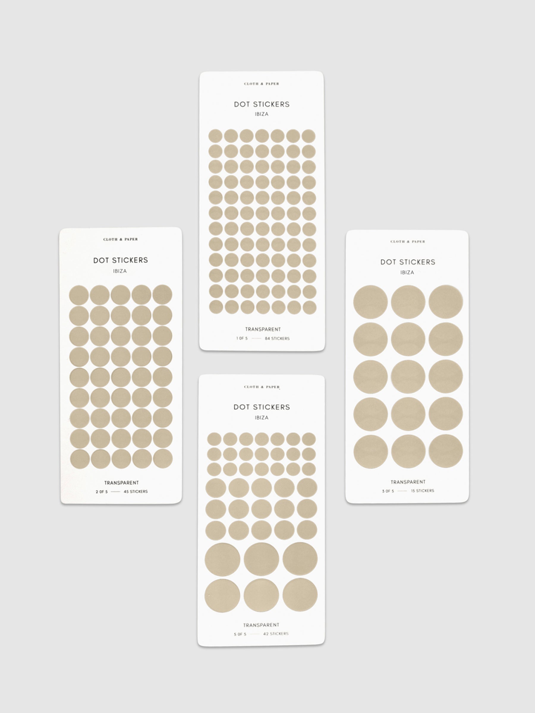 Four sheets of Ibiza dot stickers with varying sizes placed parallel to each other on a neutral background.