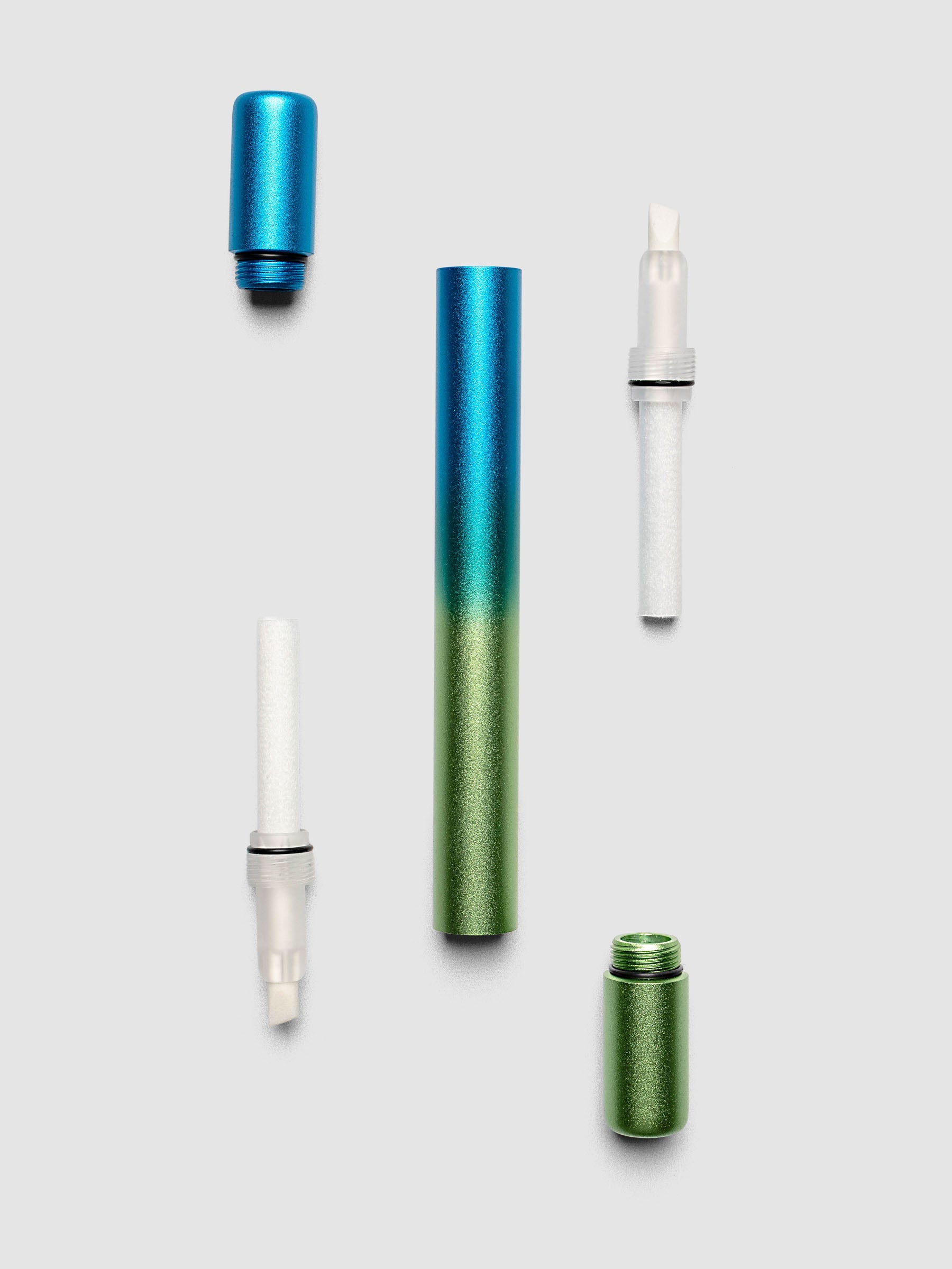 Tom's Studio Ori Refillable Highlighter disassembled into blue cap green cap blue and green ombre barrel and two white ink reservoirs with chisel tips