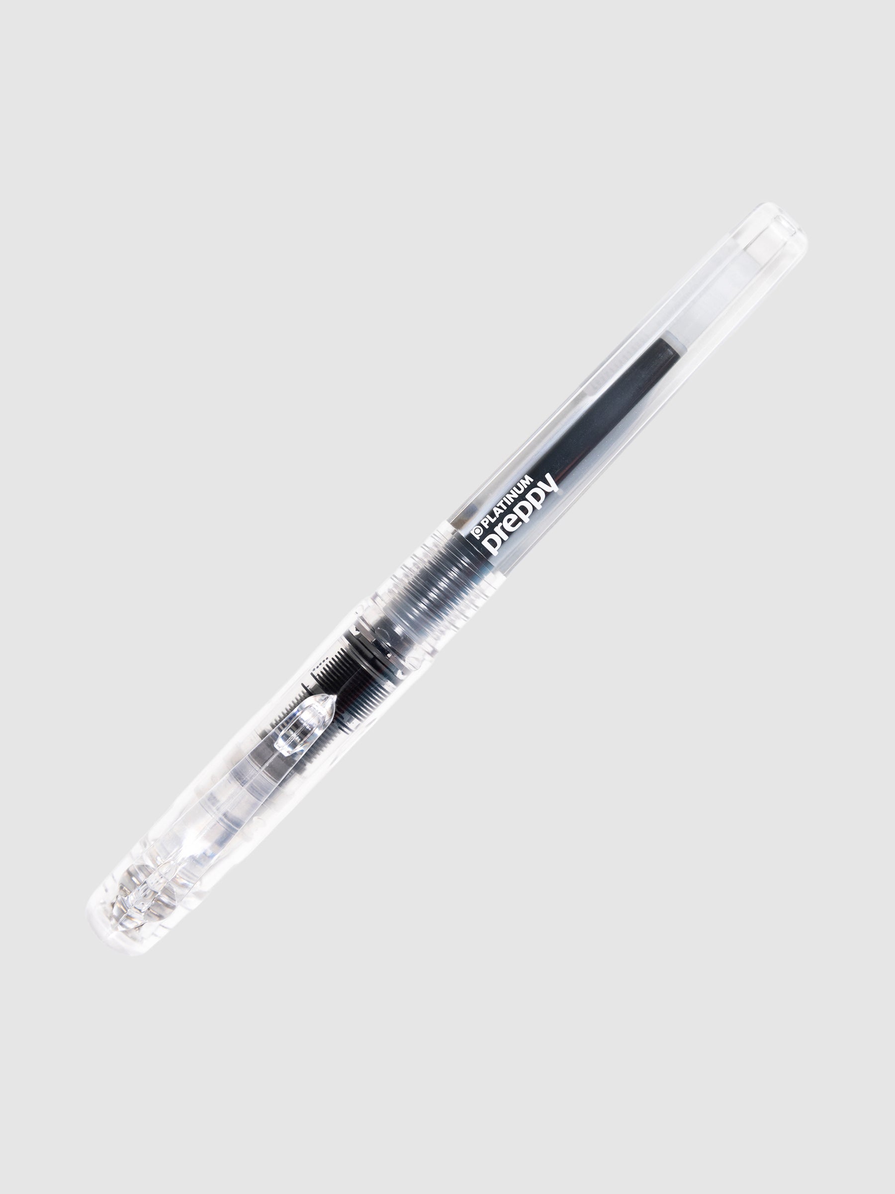 Platinum Preppy Fountain Pen, Crystal, Cloth and Paper. Pen turned to the right against a neutral background.