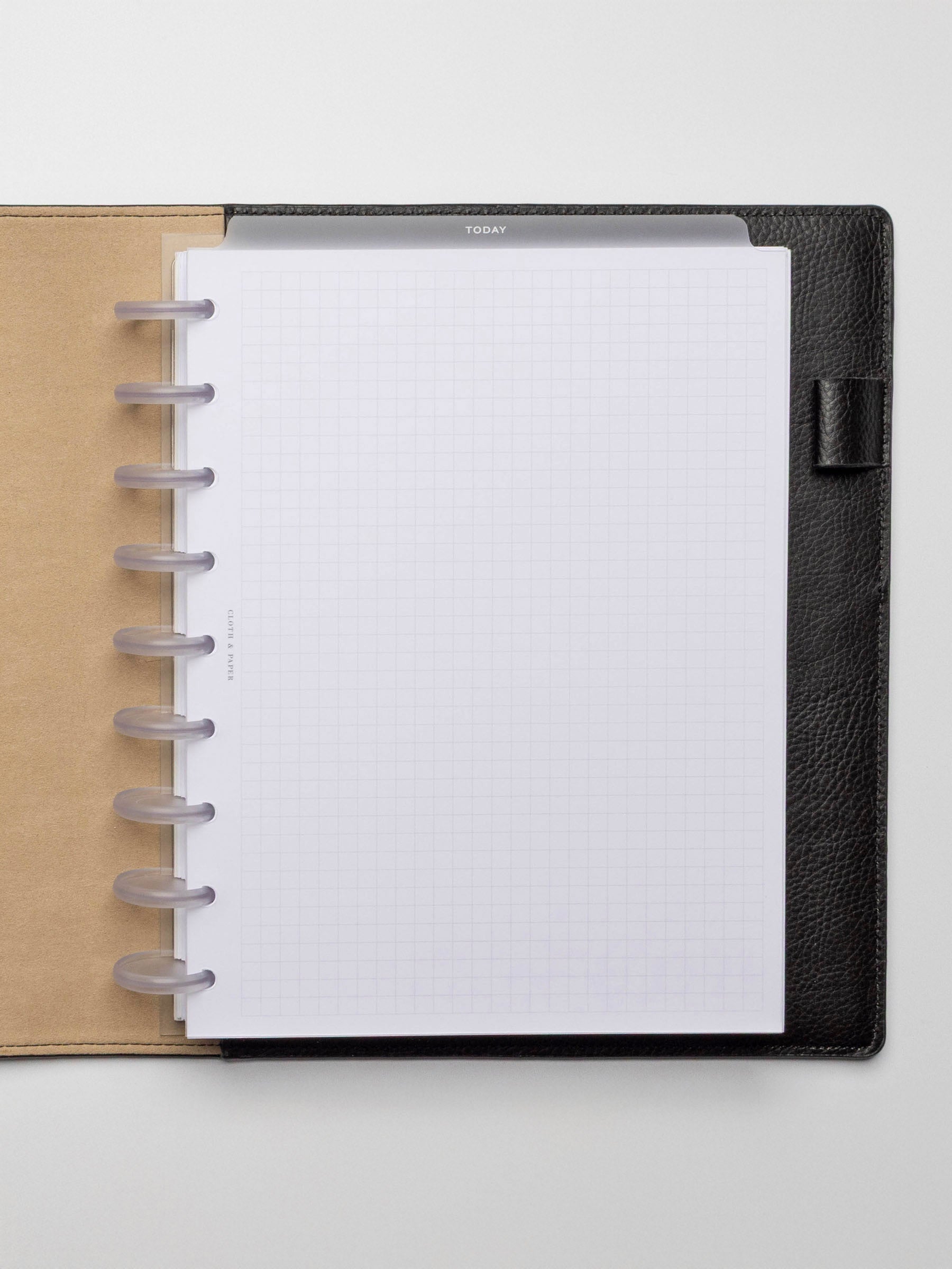 White foil divider displayed in a black leather planner.