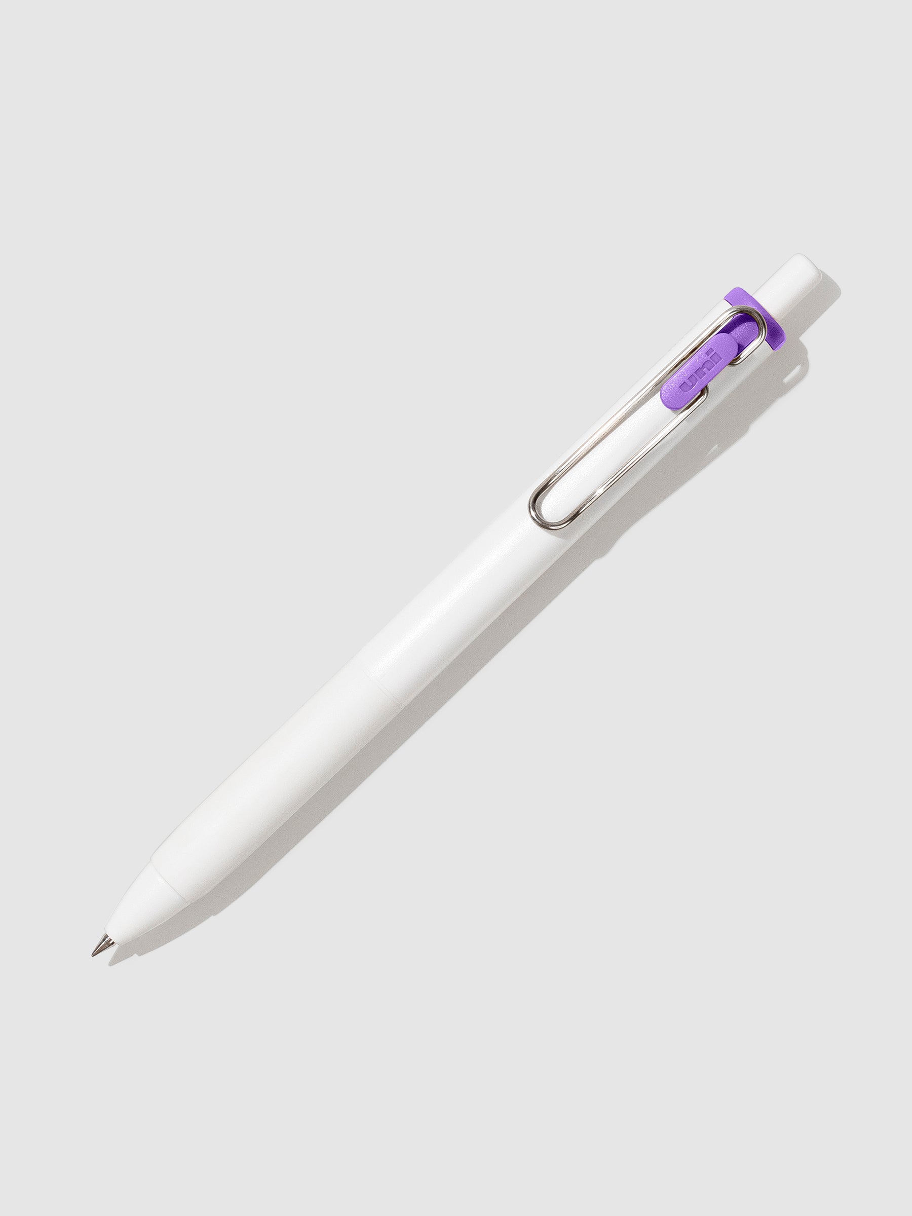 Uni-ball One Gel Pen, Twilight Purple, Cloth and Paper. Pen tilted slightly to the right on a neutral background.