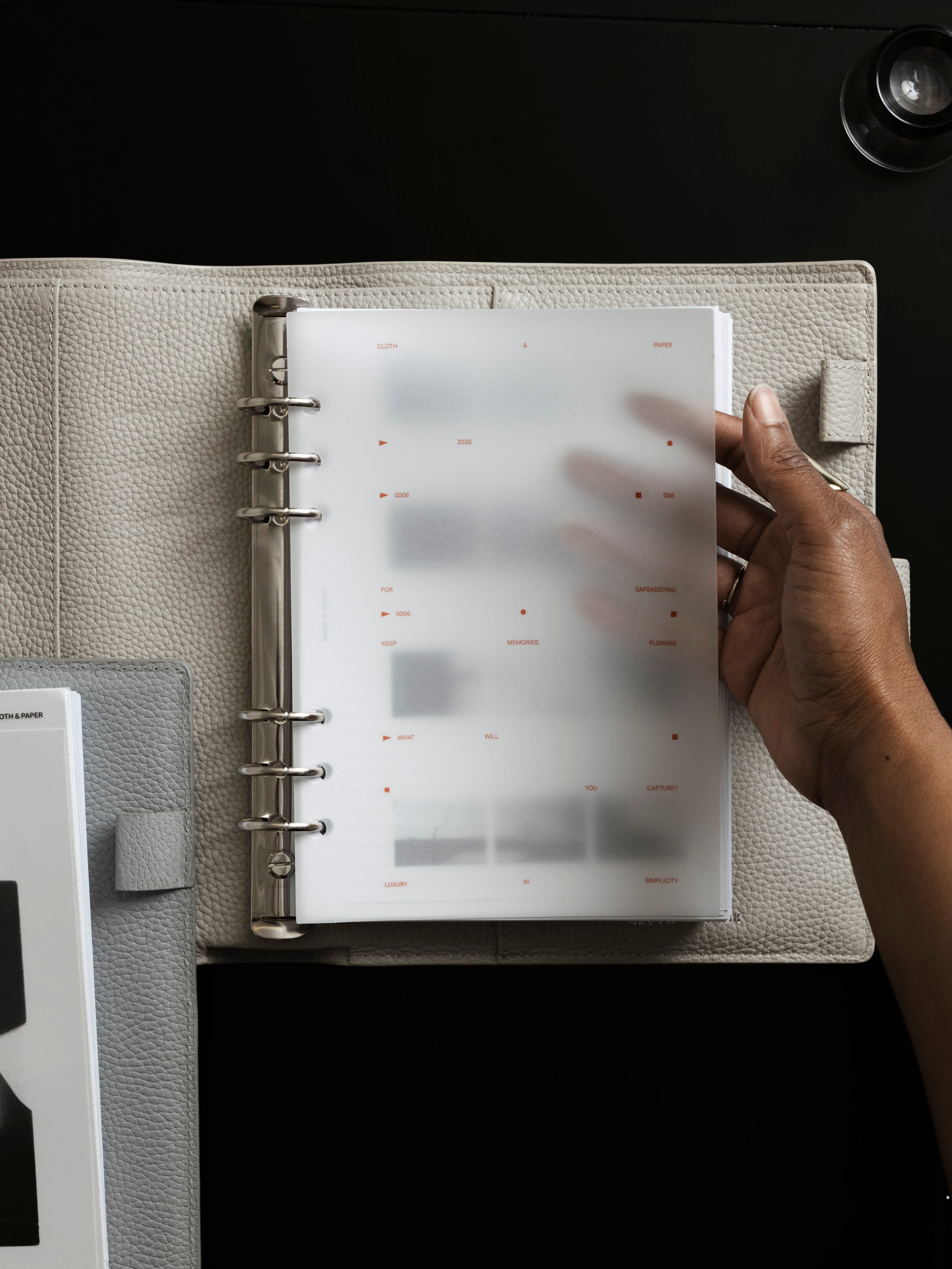 Film Strip Planner Dashboard Duo A5 6-Ring Punch lifestyle image of woman lifting vellum top dashboard inside an open A5 planner