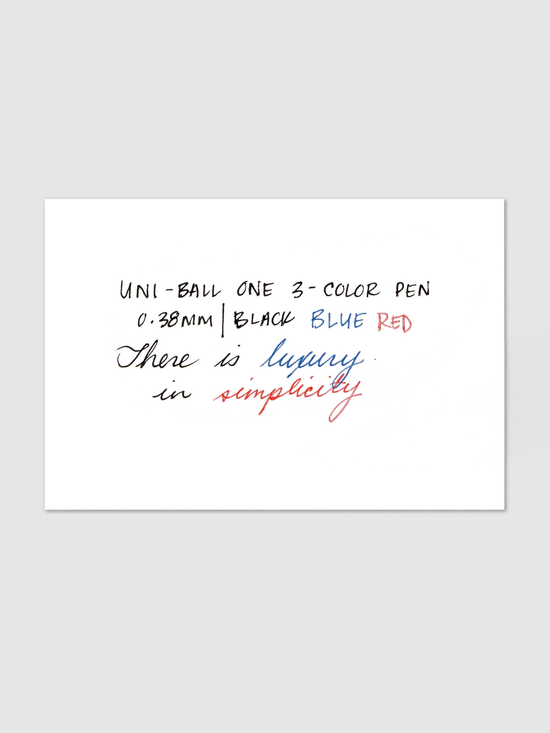 Uni-ball One 3-Color Ballpoint Pen handwriting swatch card showing black blue and red ink with sample text