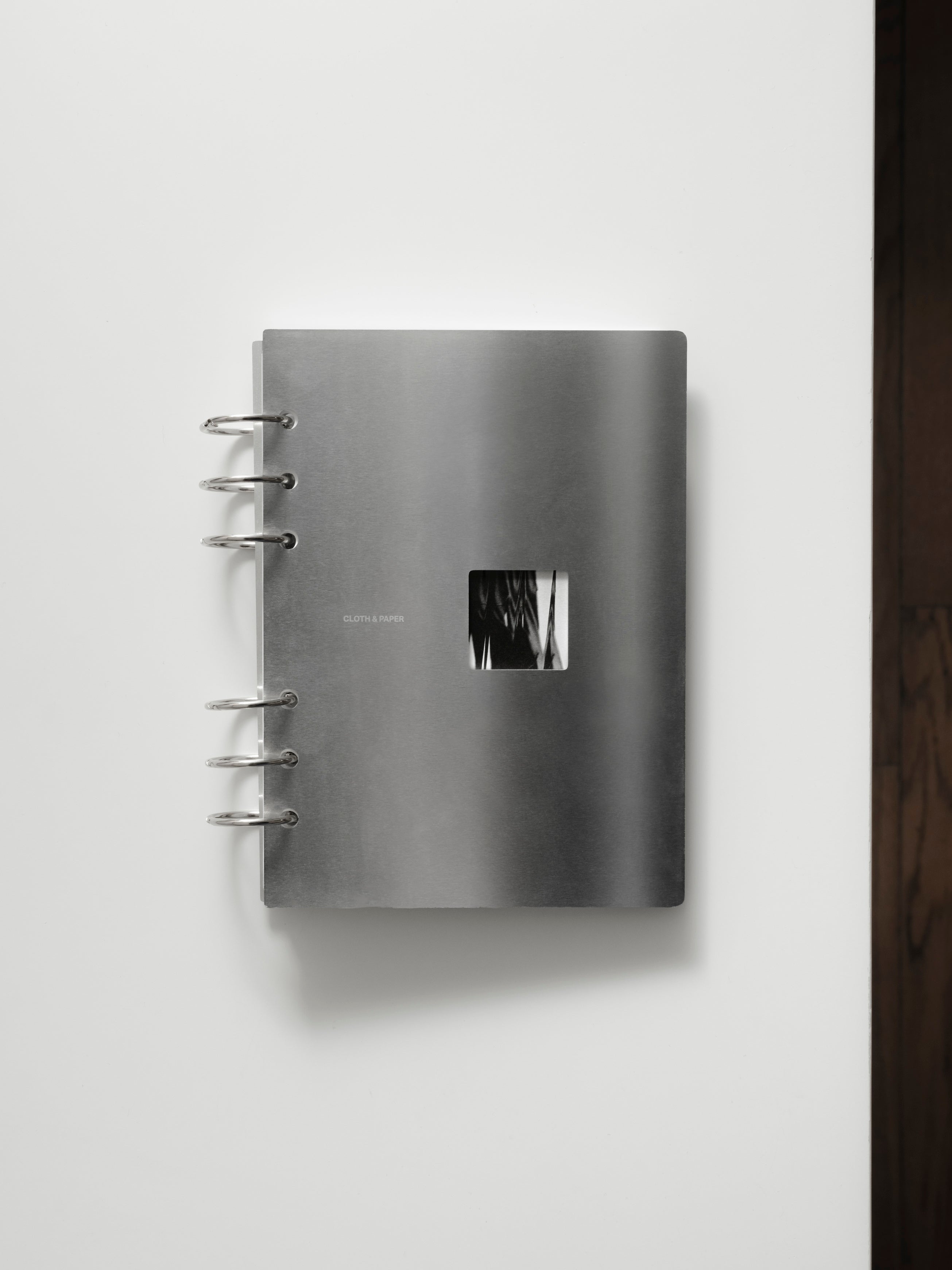 Personal Wide Clad Cover Set closed, silver metallic front cover with small square cutout window, shown against a white background