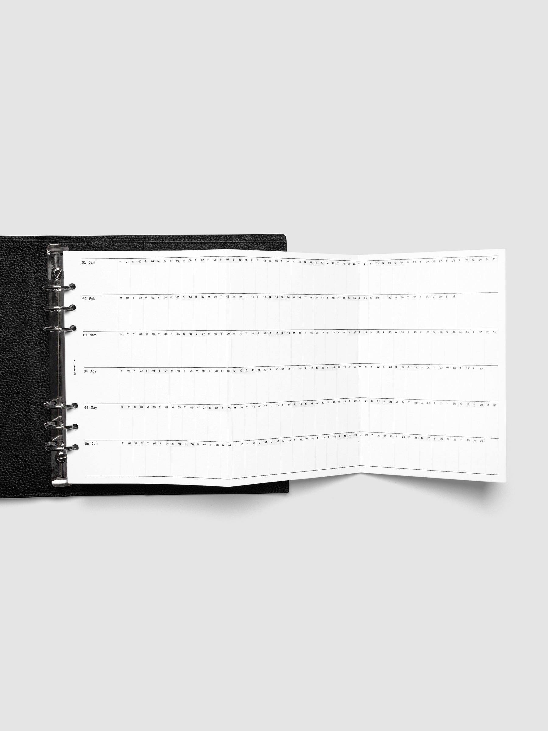 2027 Dated Fold Out Insert fully unfolded inside a A5 6-Ring Punch 6-ring planner, showing six months of dated calendar boxes across one side.