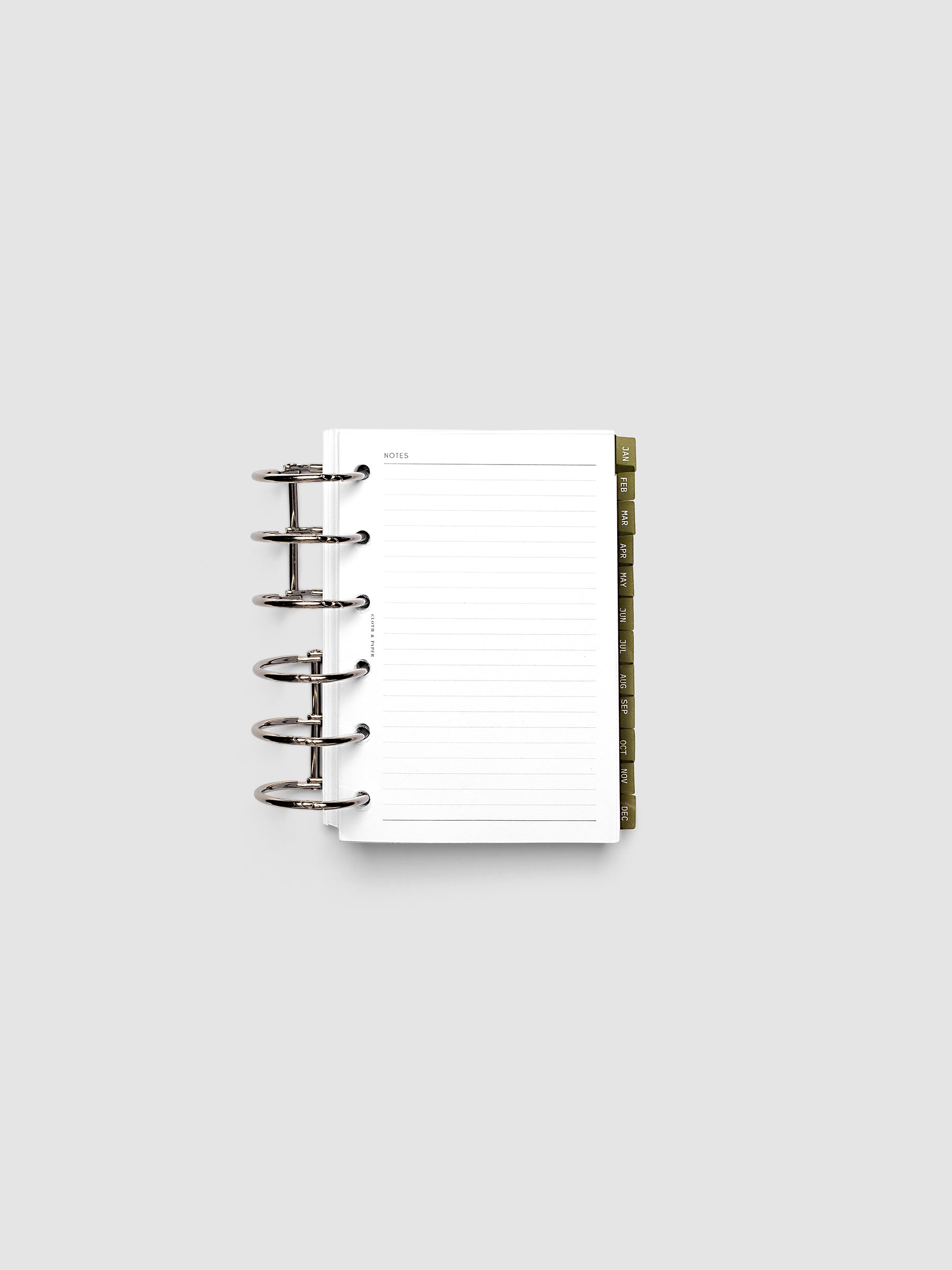 Pocket 6-Ring Punch Ultra-Thin Monthly Dividers in olive green shown tabbed inside a planner