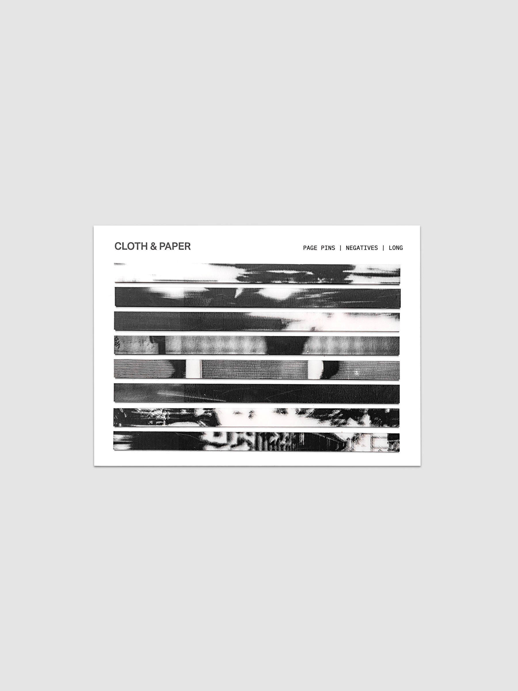Page Pins | Long | Negatives, full set of 160 transparent grey-toned film negative-style page pins on a white backing card