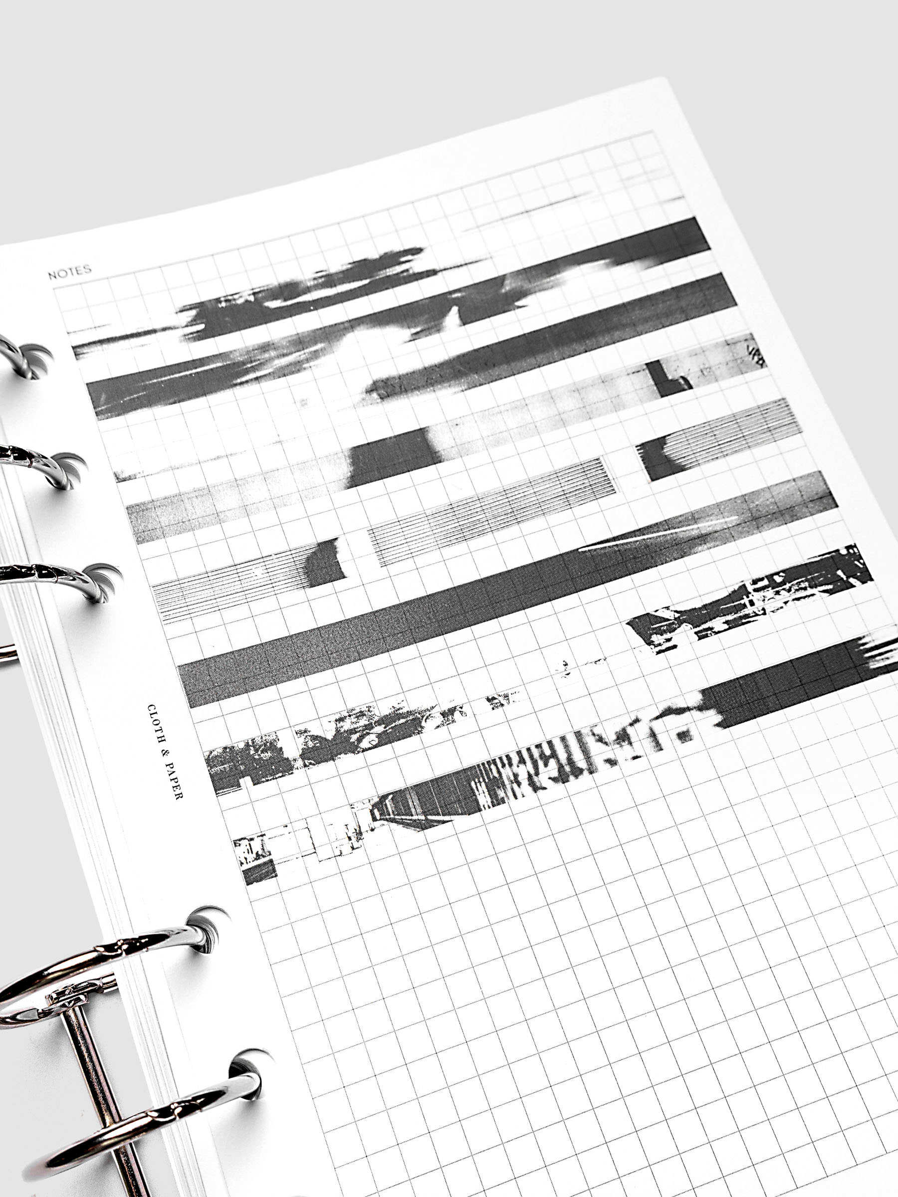 Page Pins | Long | Negatives, close-up of film negative-style transparent grey page pins on graph insert pages in a 6-ring planner