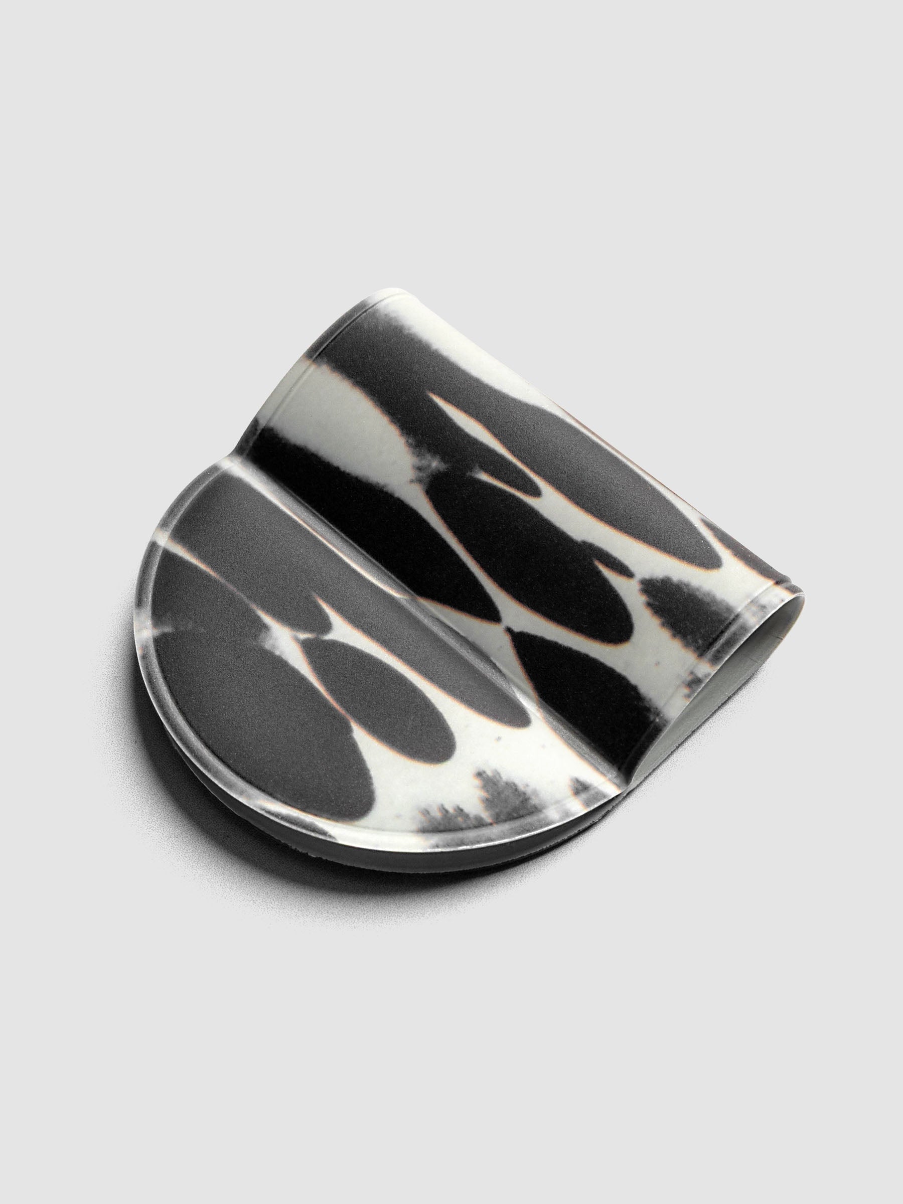 Magnetic Bookmark | Pen Holder | Vinyl in Dissolve, angled view showing high-contrast black and off-white oval pattern