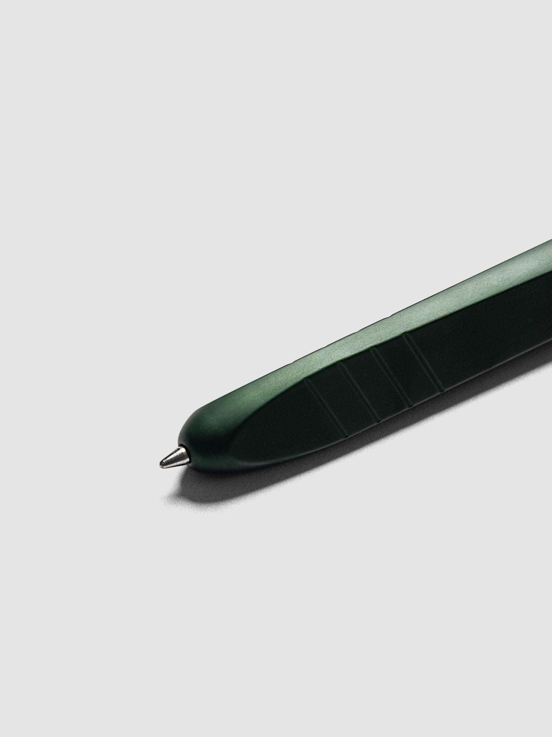 Kolo Tino Ballpoint Pen in Anodized Aluminum Verdant, close-up of the tip extended showing the medium conical metal tip and textured grip section