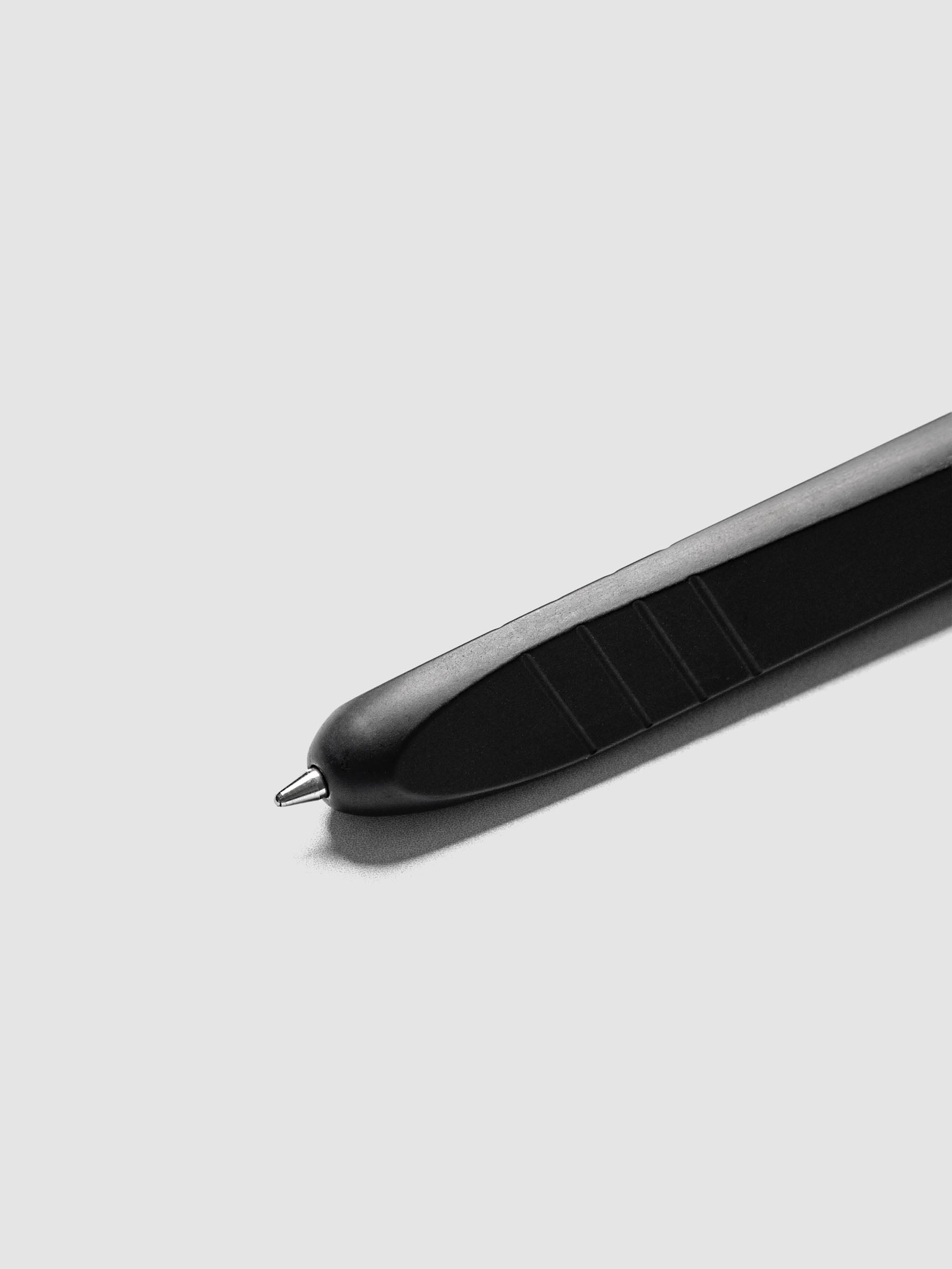 Kolo Tino Ballpoint Pen in Anodized Aluminum Noir, close-up of the tip extended showing the medium conical metal tip and textured grip section