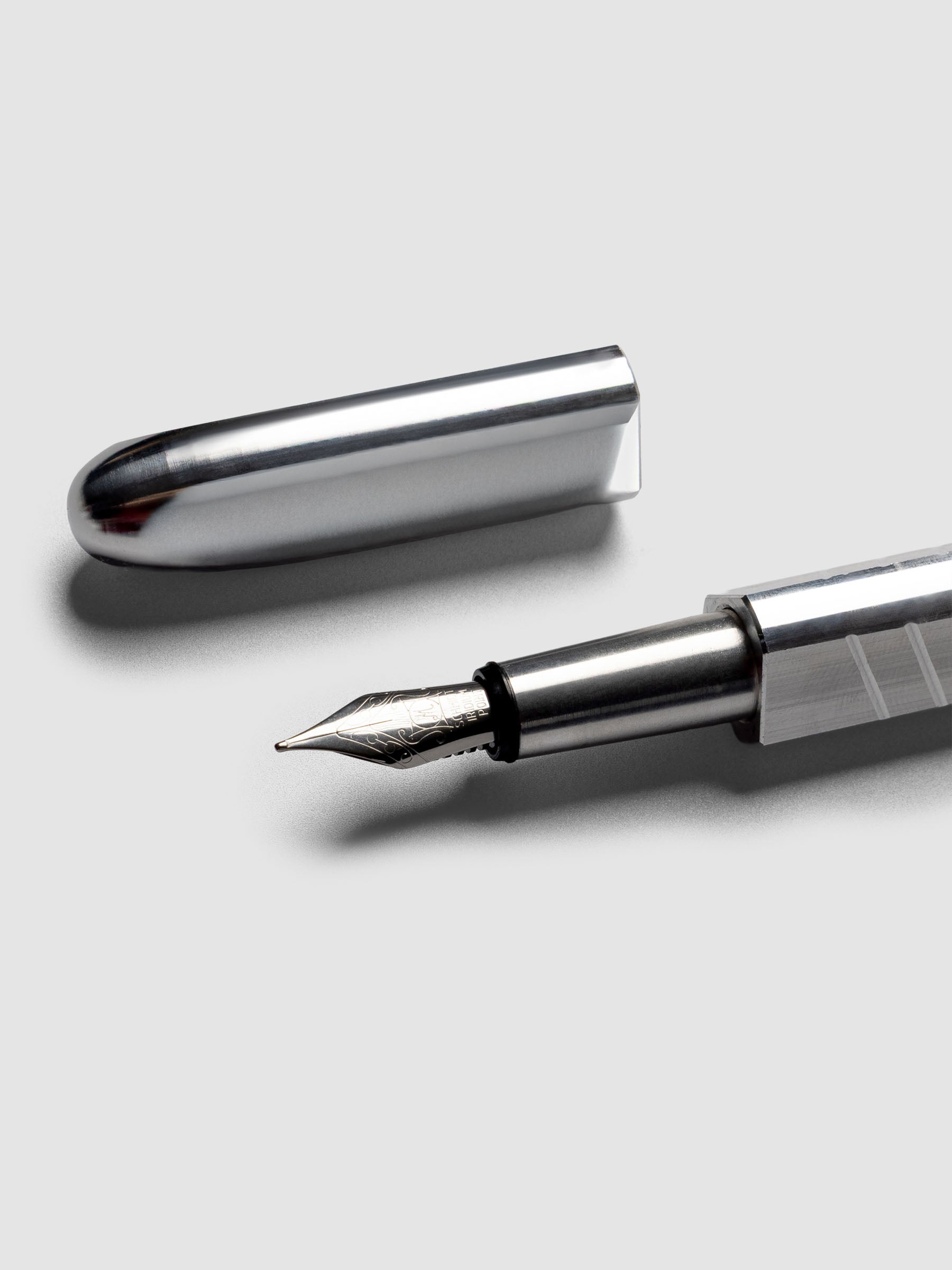 Kolo Tino Fountain Pen in the color Raw Aluminum, a silver toned metal barrel and a silver medium nib shown with cap off.