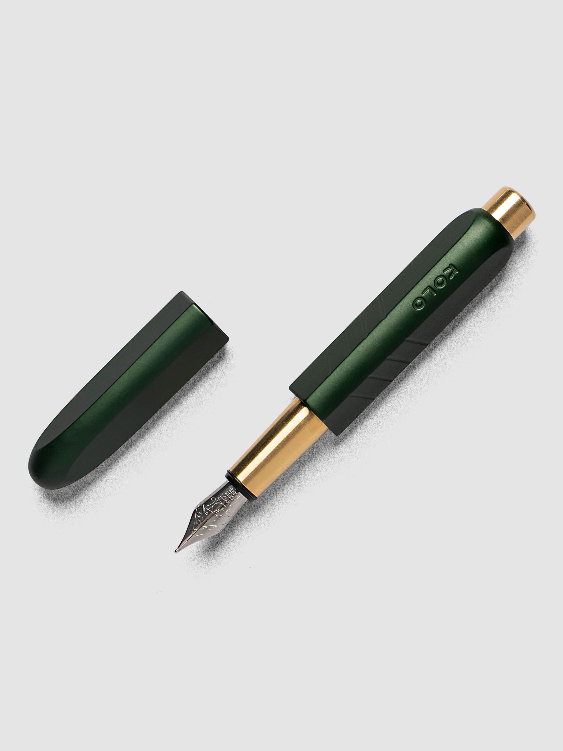 Kolo Tino Fountain Pen in Anodized Aluminum Verdant, a deep forest green barrel with gold accents and silver medium nib shown with cap off, full pen view