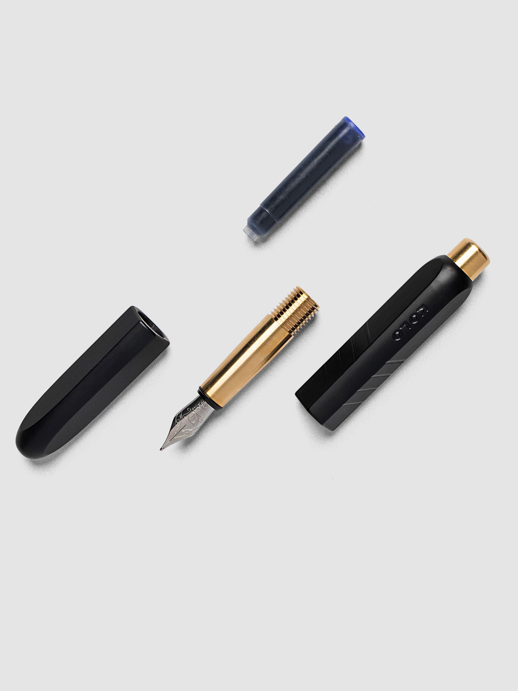 Kolo Tino Fountain Pen in Anodized Aluminum Noir fully disassembled showing cap, nib section, barrel, and ink cartridge