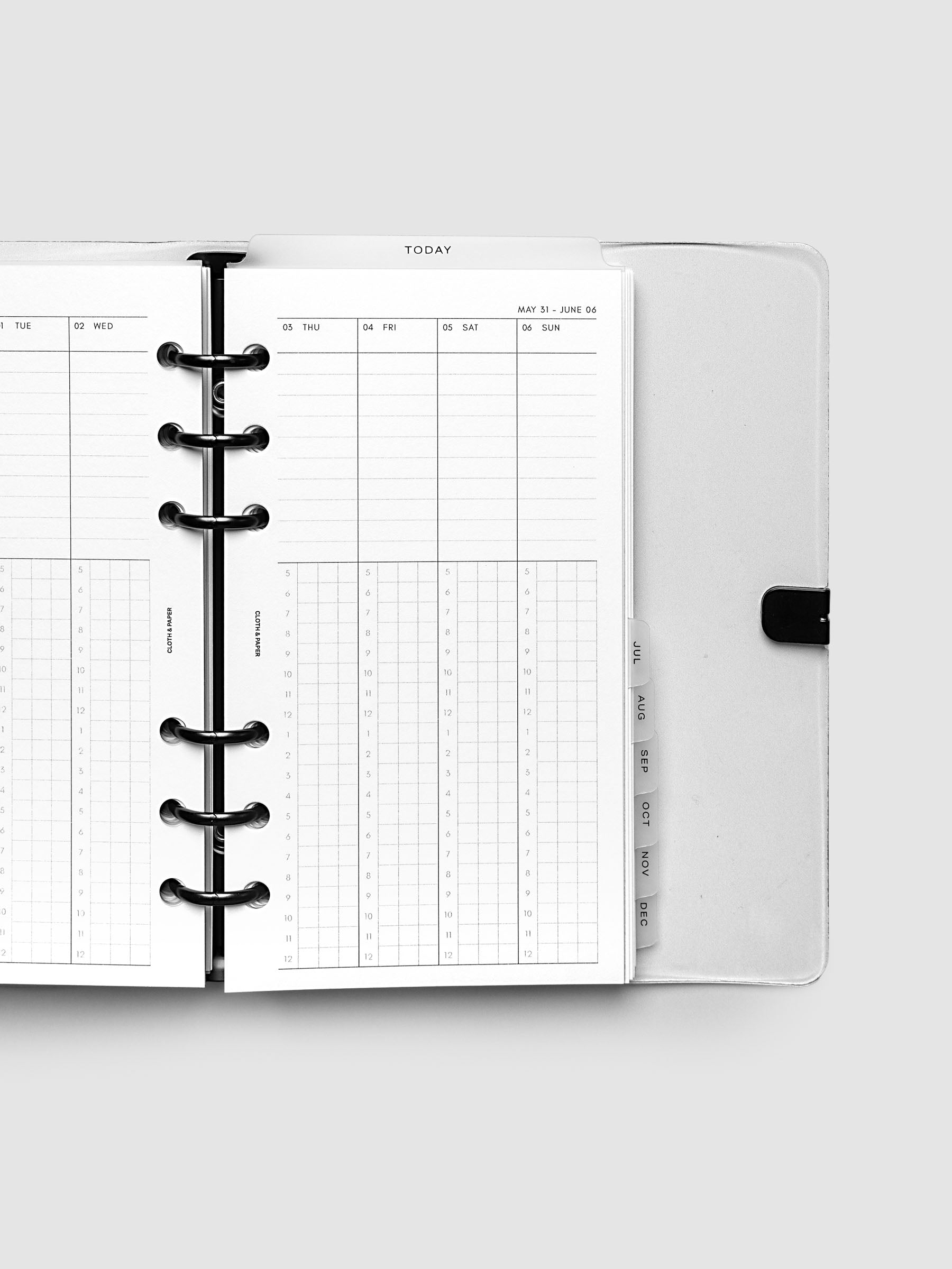 Close-up of an open planner with black 6-ring binding, weekly time block spread showing Thursday through Sunday columns with a task list above and an hourly grid below, tabbed monthly dividers visible at the edge, Personal 6-Ring Punch size