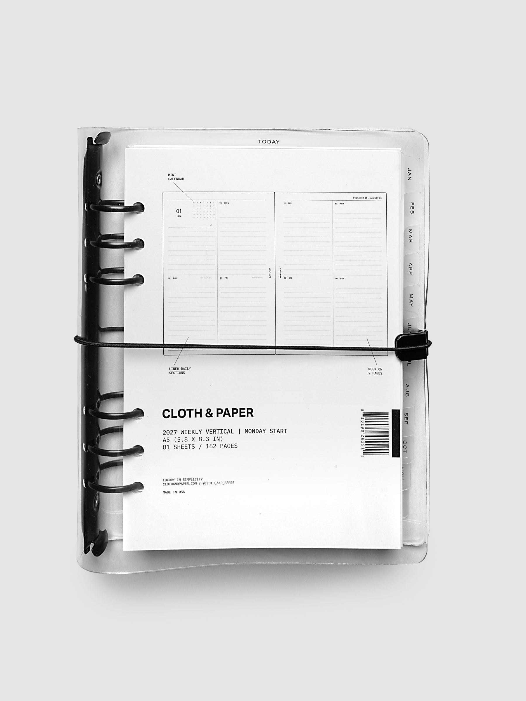 Closed clear vinyl planner cover with black 6-ring binding and a black elastic closure, front page displaying a labeled weekly vertical spread with mini calendar, lined daily sections, and week on two pages callouts, A5 6-Ring Punch size