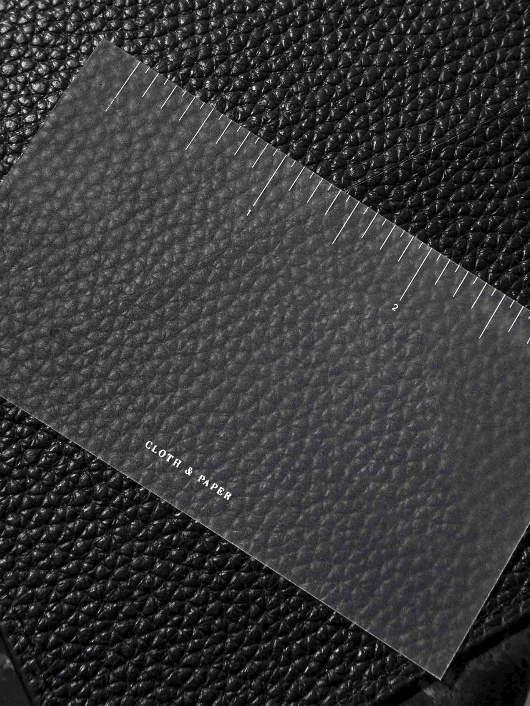 Ruler journaling card laying on top of the corner of a black leather agenda. 