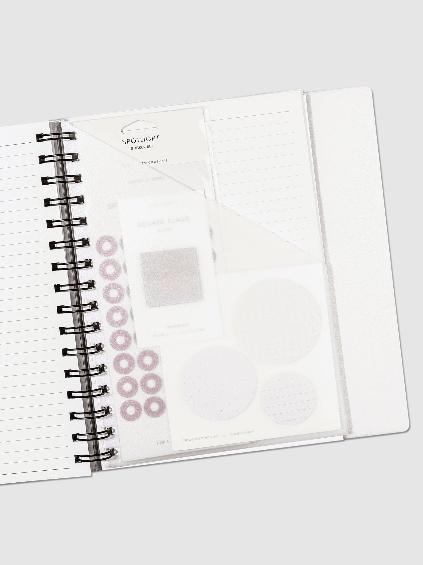 A5 Spiral folder in use inside a lined notebook, with accessories in the folder pocket